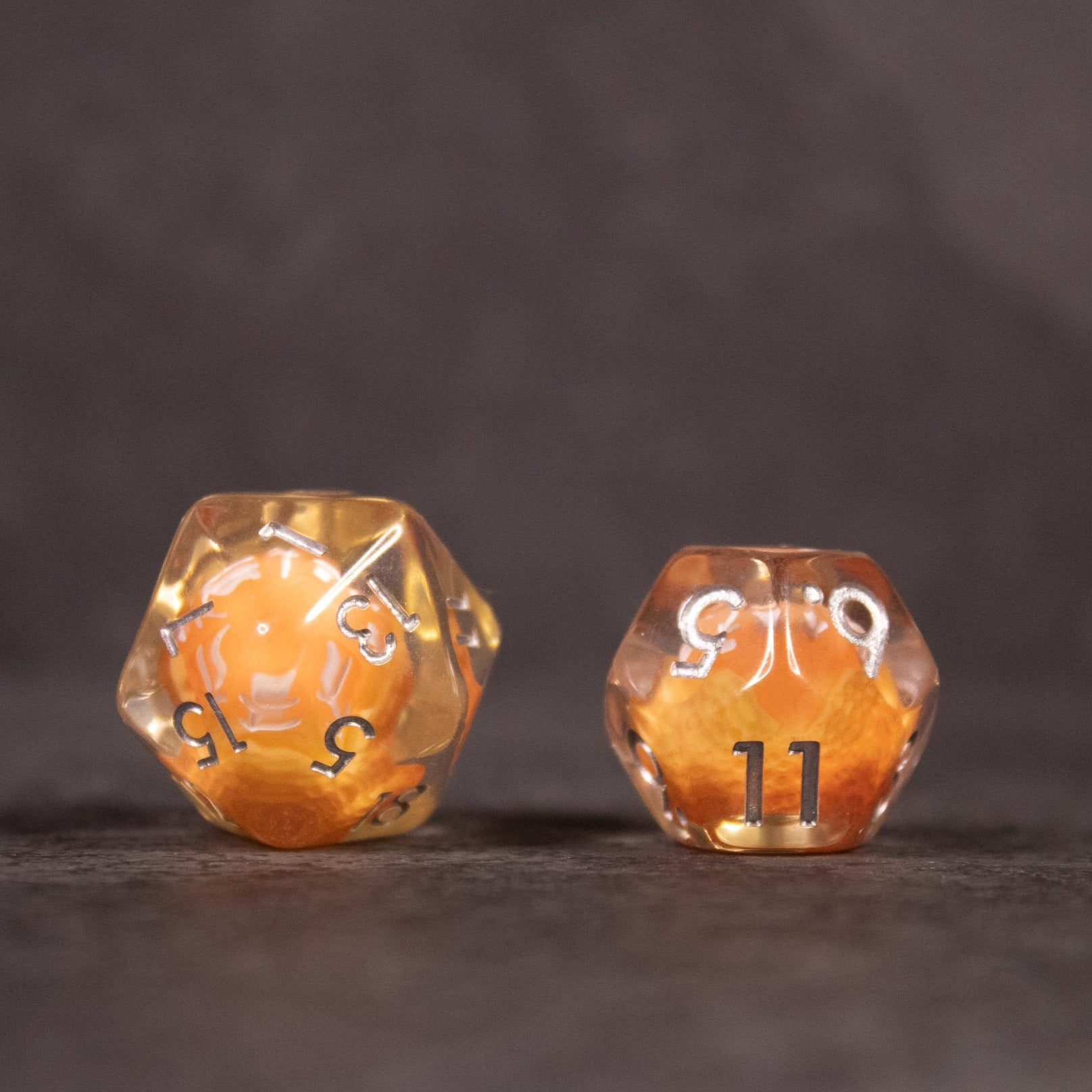 Orange Fruit Dice Set - Two clear polyhedral dice with miniature orange fruit inside, white numbers on each face.