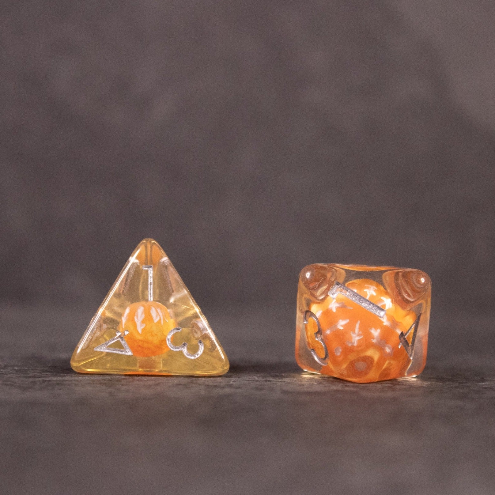 Orange Fruit Dice Set - Transparent orange four-sided and six-sided dice with small orange fruit pieces inside and white numbering.