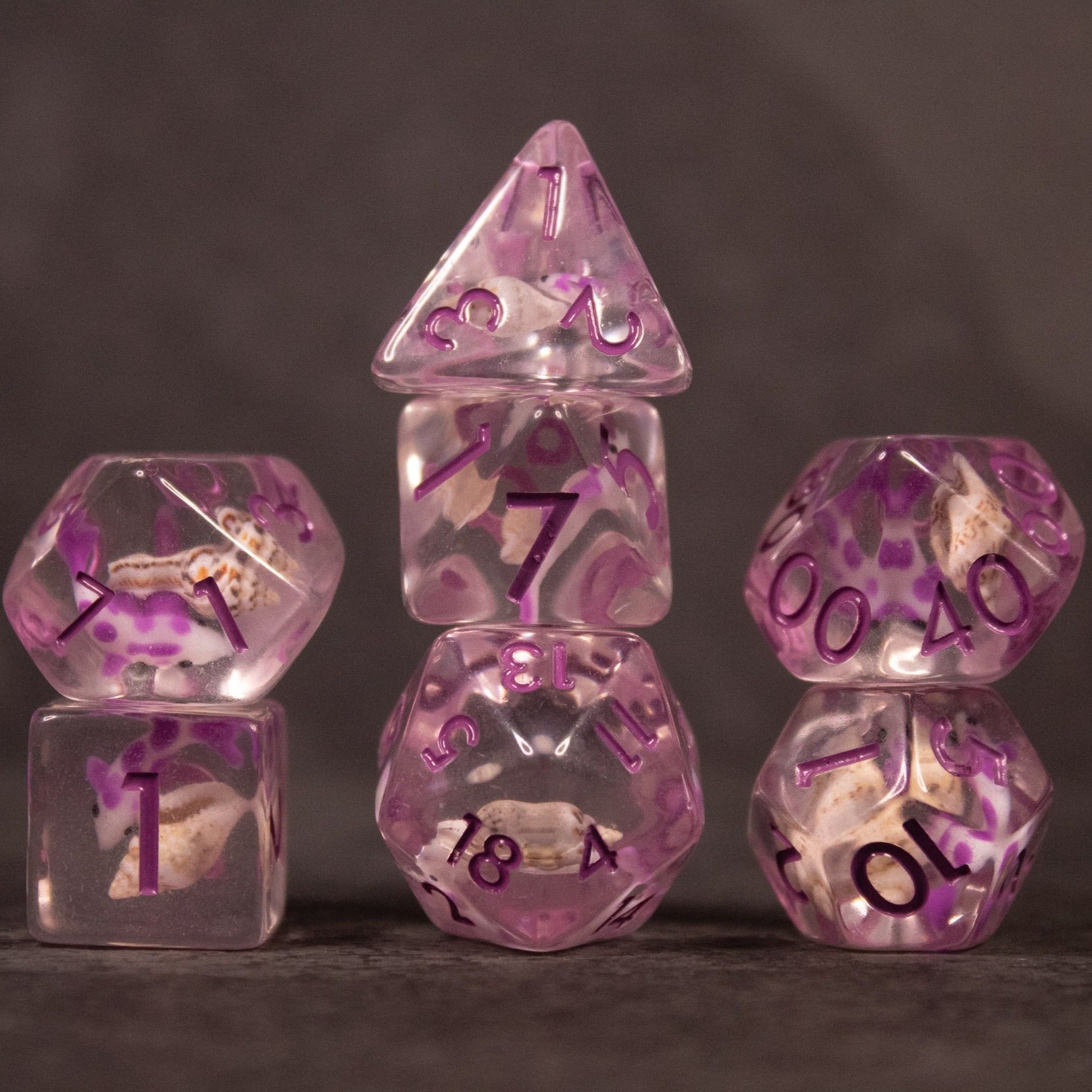 Purple Koi Fish and Seashell Dice Set - Set of translucent purple dice with koi fish and seashell inclusions, featuring various polyhedral shapes.