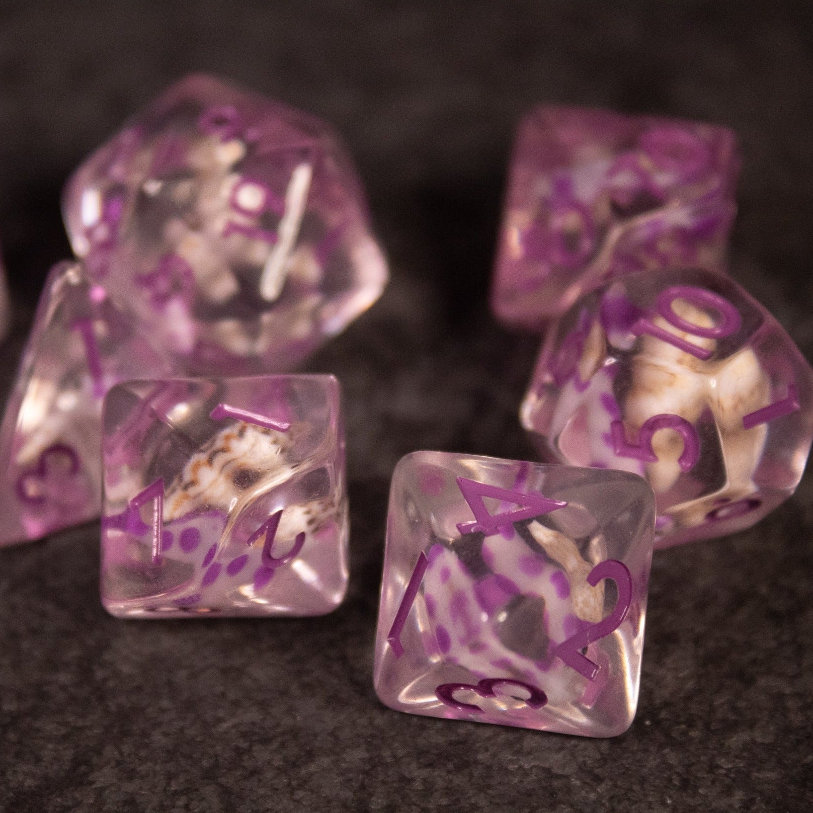 Purple Koi Fish and Seashell Dice Set - Translucent purple resin dice set with embedded koi fish and seashell designs, including d4, d6, d8, d10, d12, and d20.