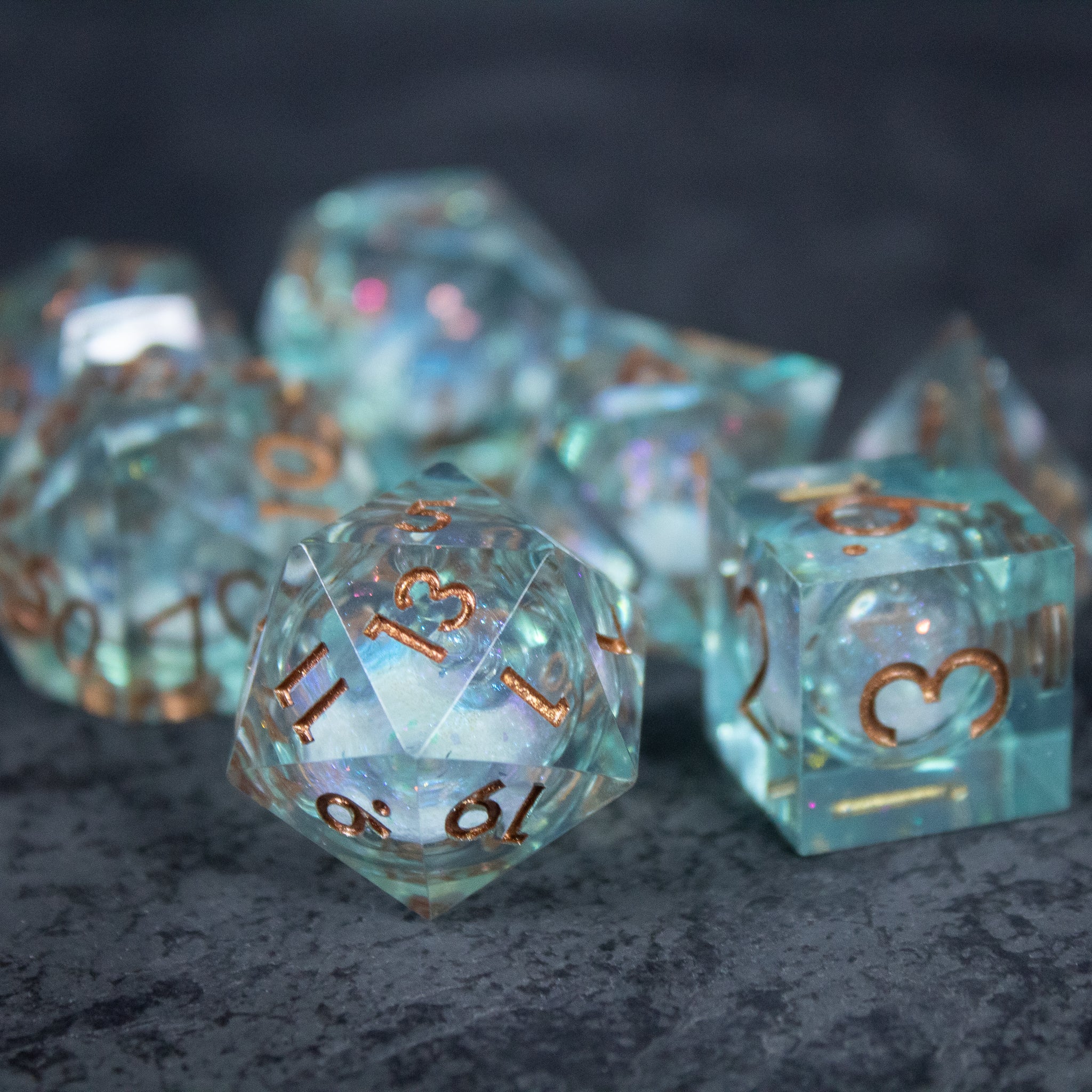 Will o' Wisp Liquid Core Dice Set - Translucent polyhedral dice set with liquid core, sharp edges, and copper-colored numbers.