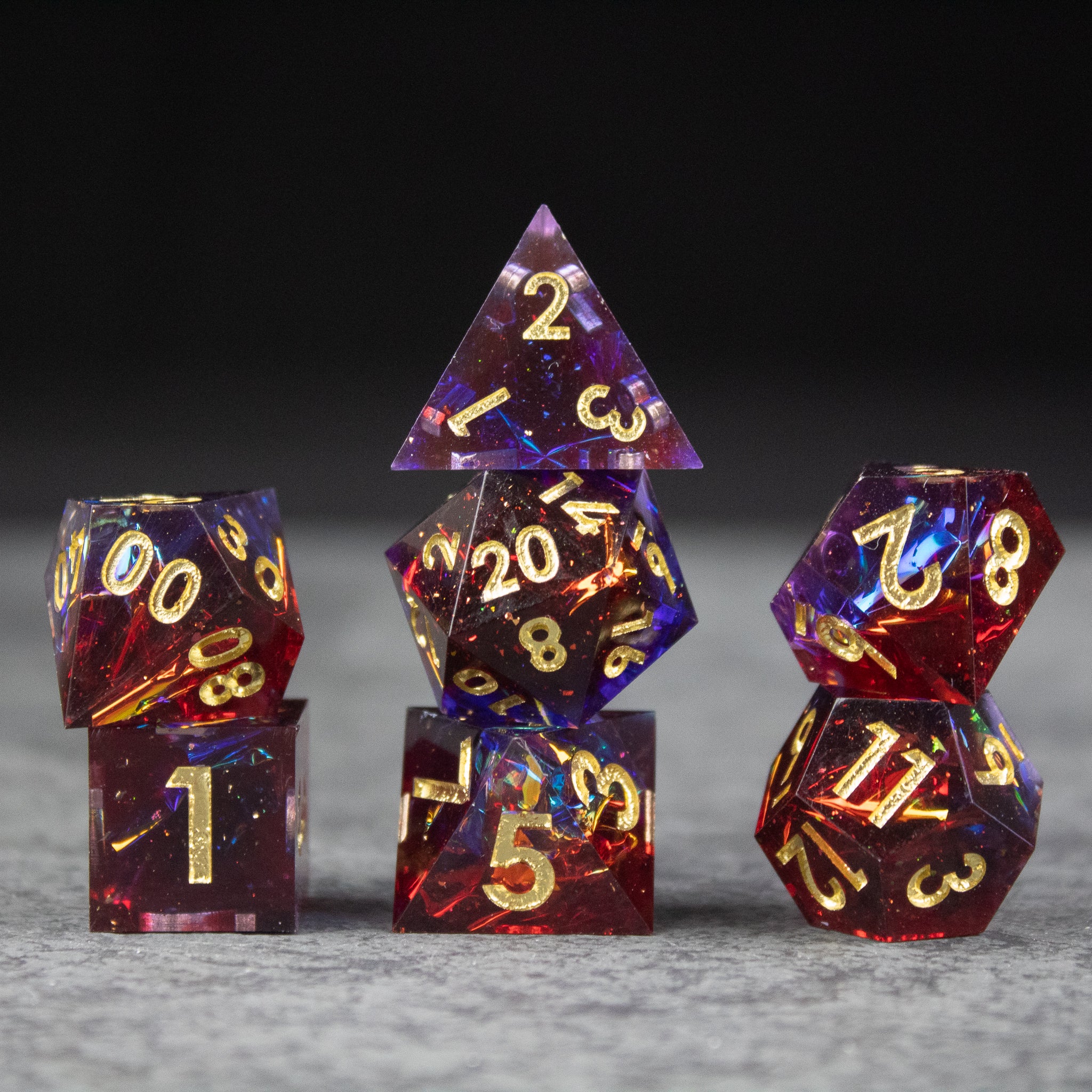 Electromancer Dice Set - Sharp-edged red and blue translucent Electromancer dice set with gold numbering, including d20, d12, d10, d8, d6, and d4.