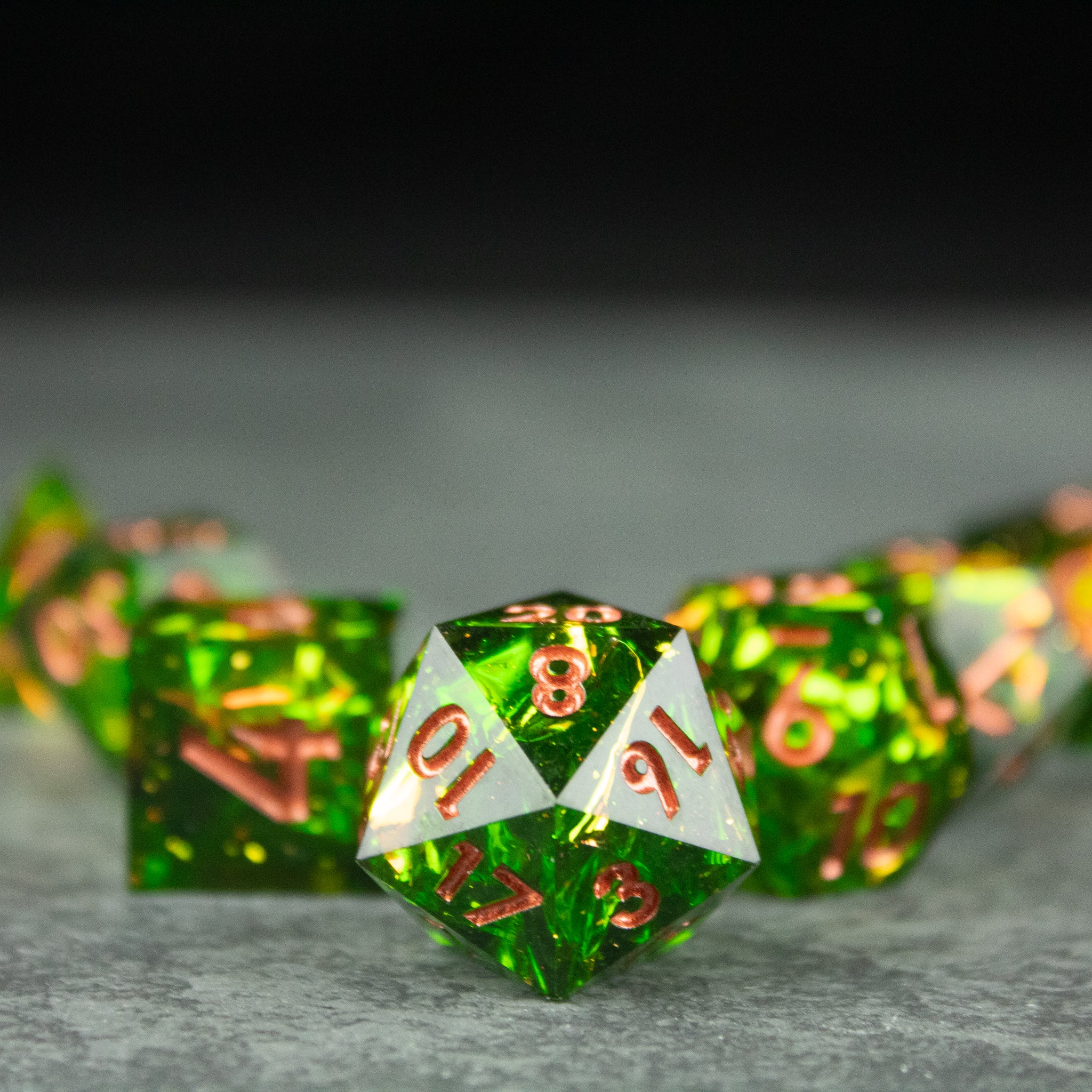 Venom Dice Set - Green translucent sharp-edged polyhedral dice with white and gold numbering, glossy finish.