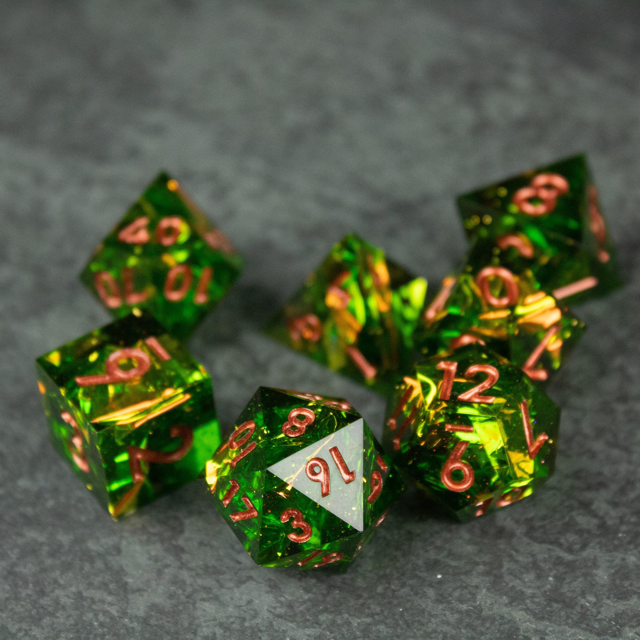 Venom Dice Set - Set of seven translucent green polyhedral dice with sharp edges and metallic copper numbers.