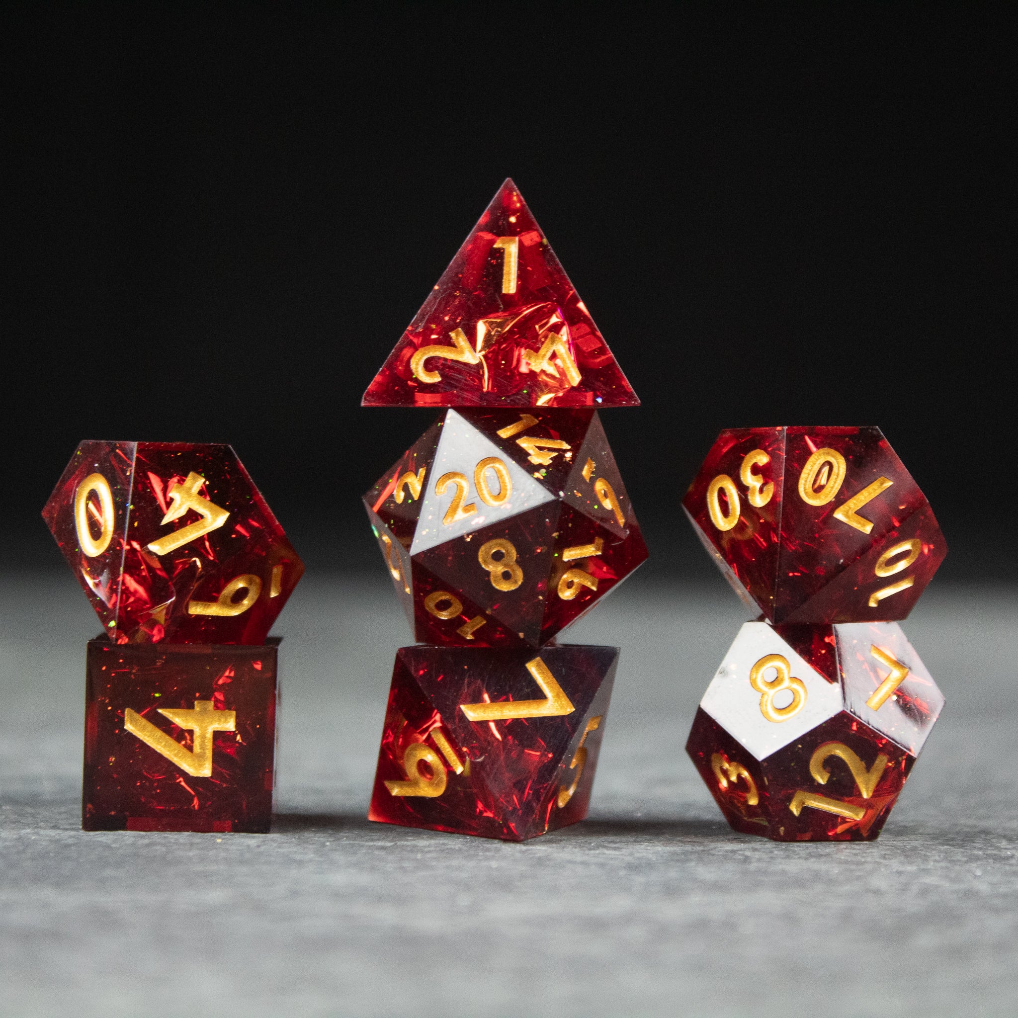 Ember Dice Set - Set of seven sharp-edged red dice with gold numbering, featuring a glowing ember pattern.