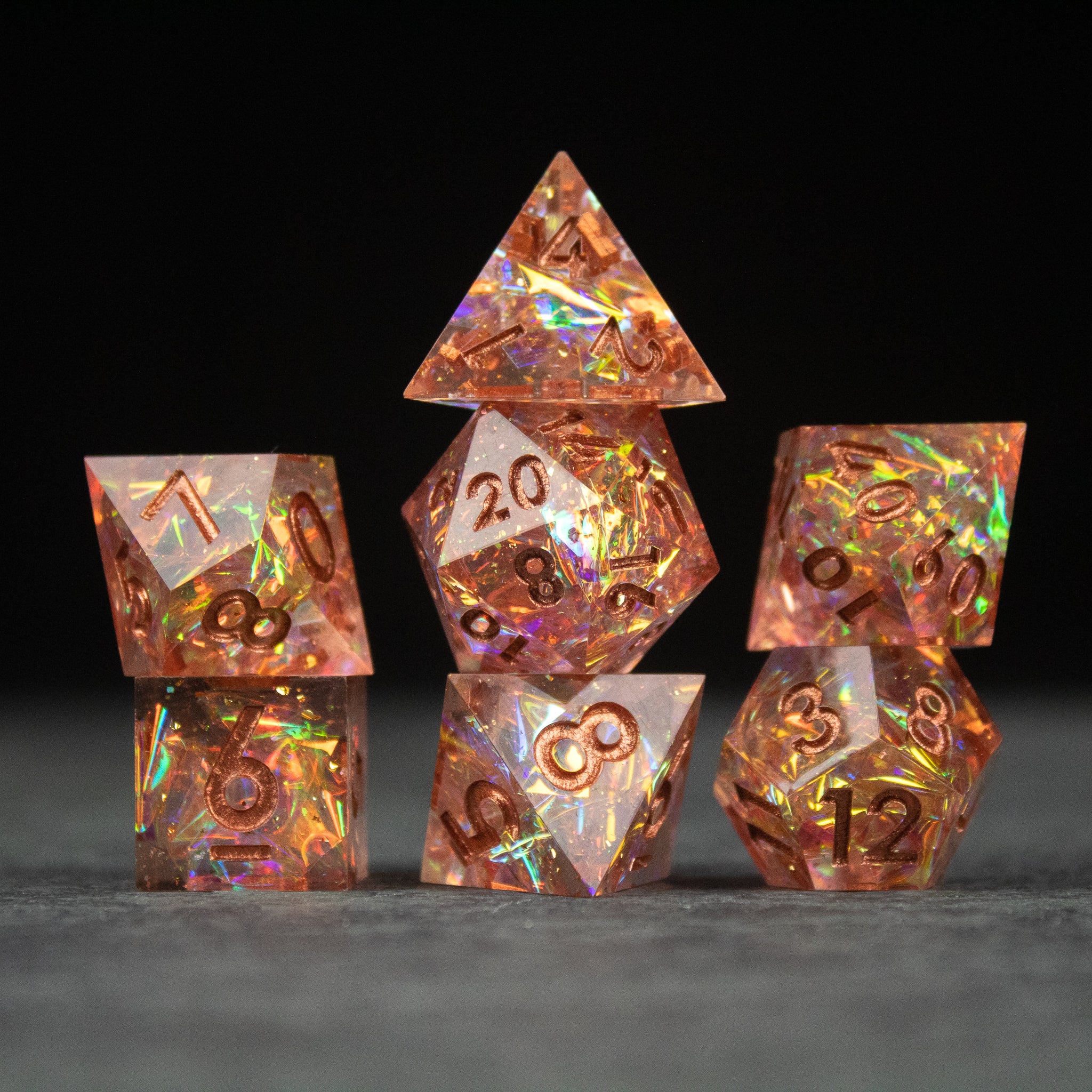 Sacred Flame Dice Set - Set of seven transparent orange polyhedral dice with sharp edges and iridescent flames inside.