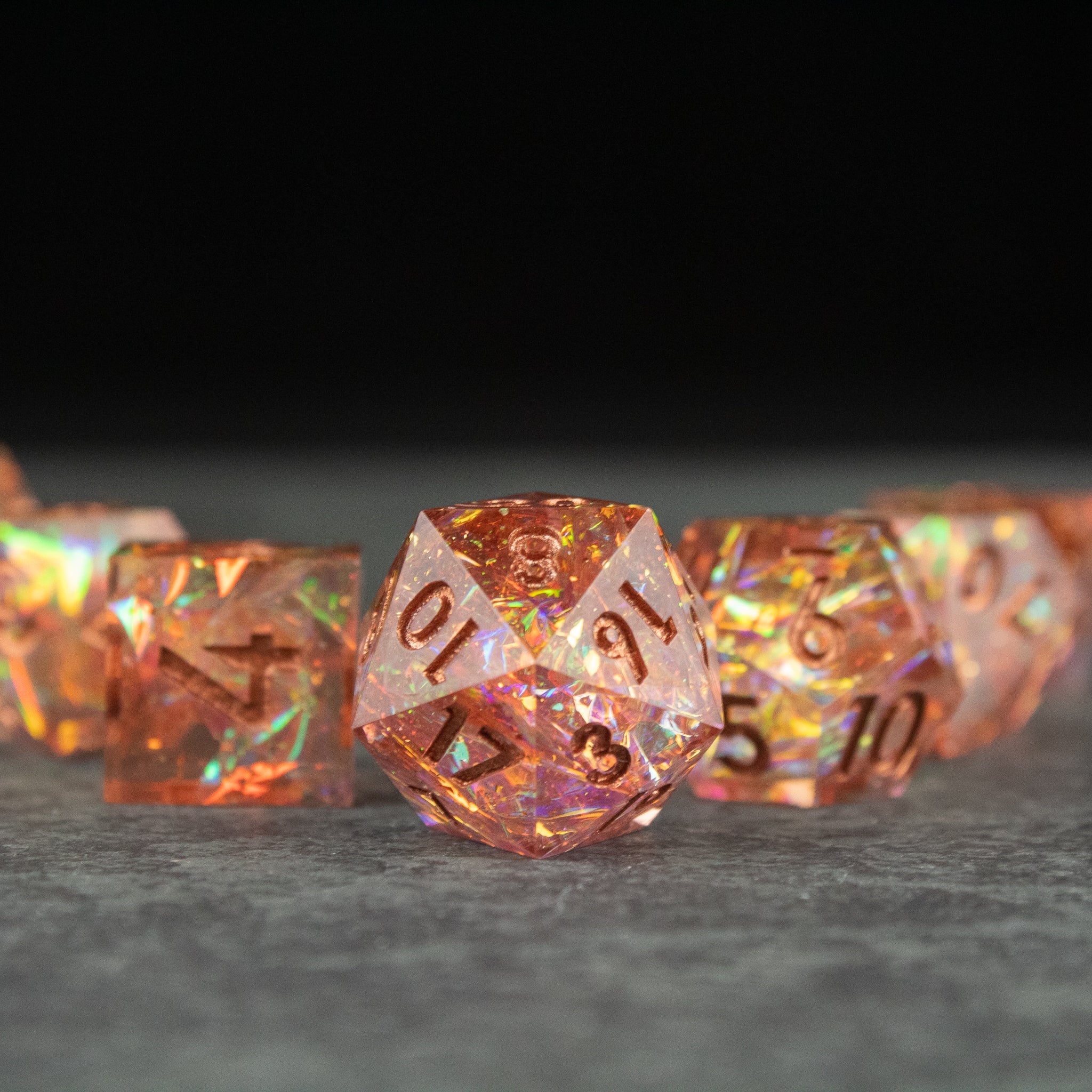 Sacred Flame Dice Set - Translucent orange polyhedral dice set with sharp edges and gold numbering, glowing with internal sparkles.