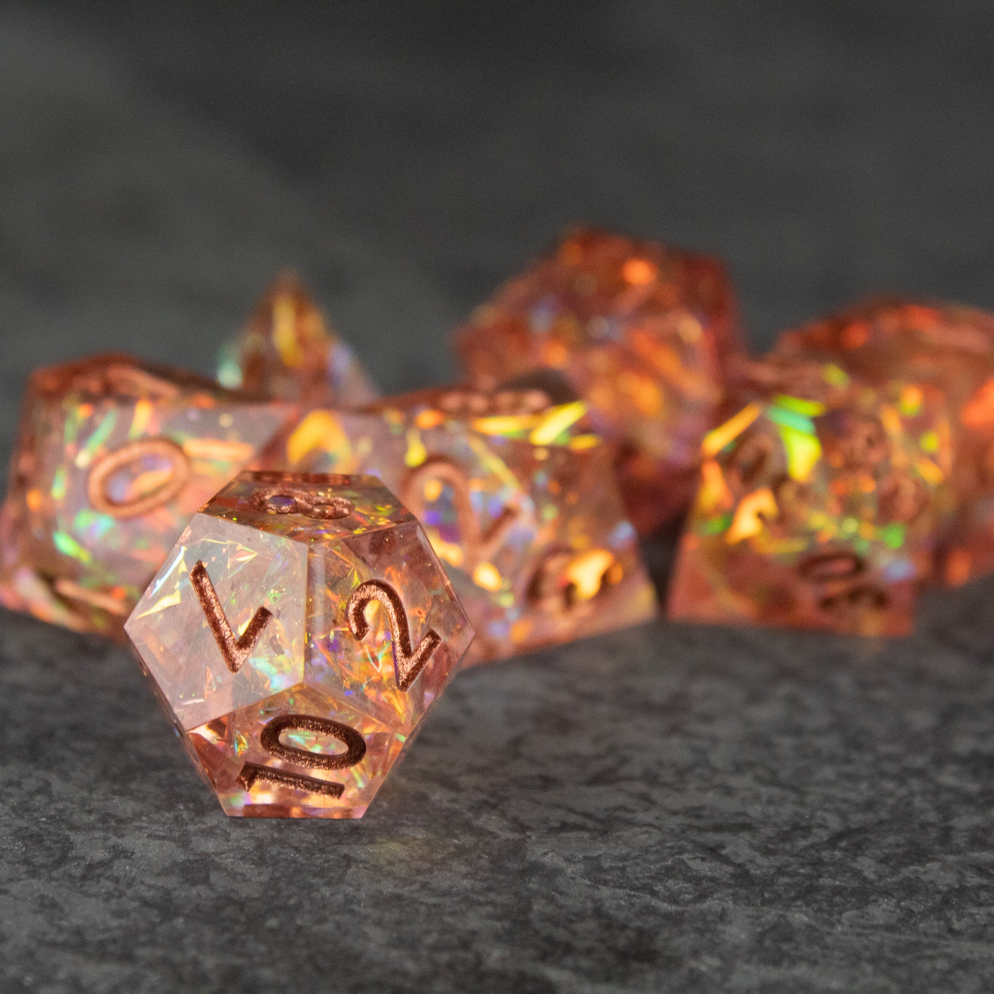 Sacred Flame Dice Set - Orange translucent sharp-edged polyhedral dice set with gold numbering and shimmering internal flecks.