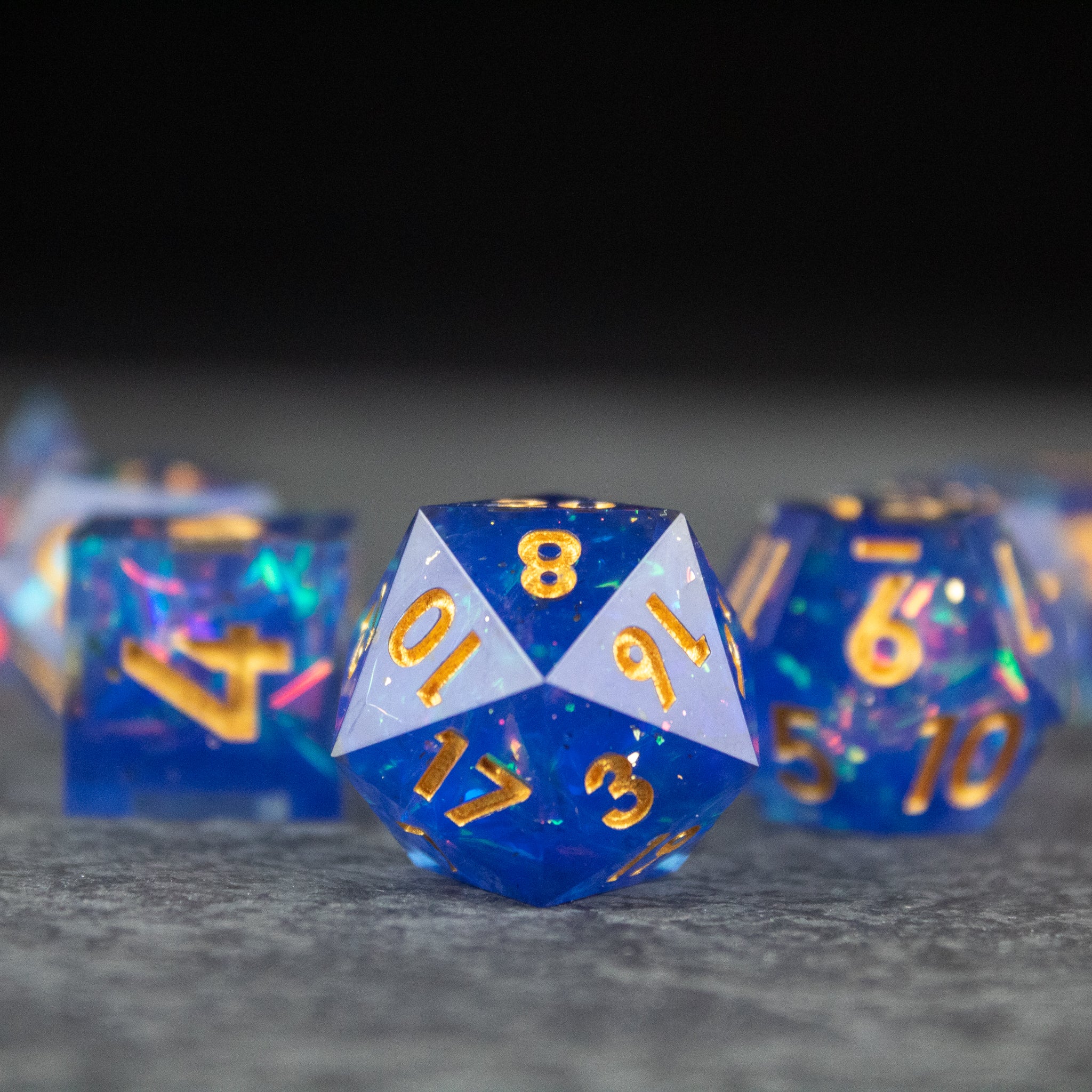 Arcana Dice Set - Blue sharp edge polyhedral dice set with gold numbering and speckled design.