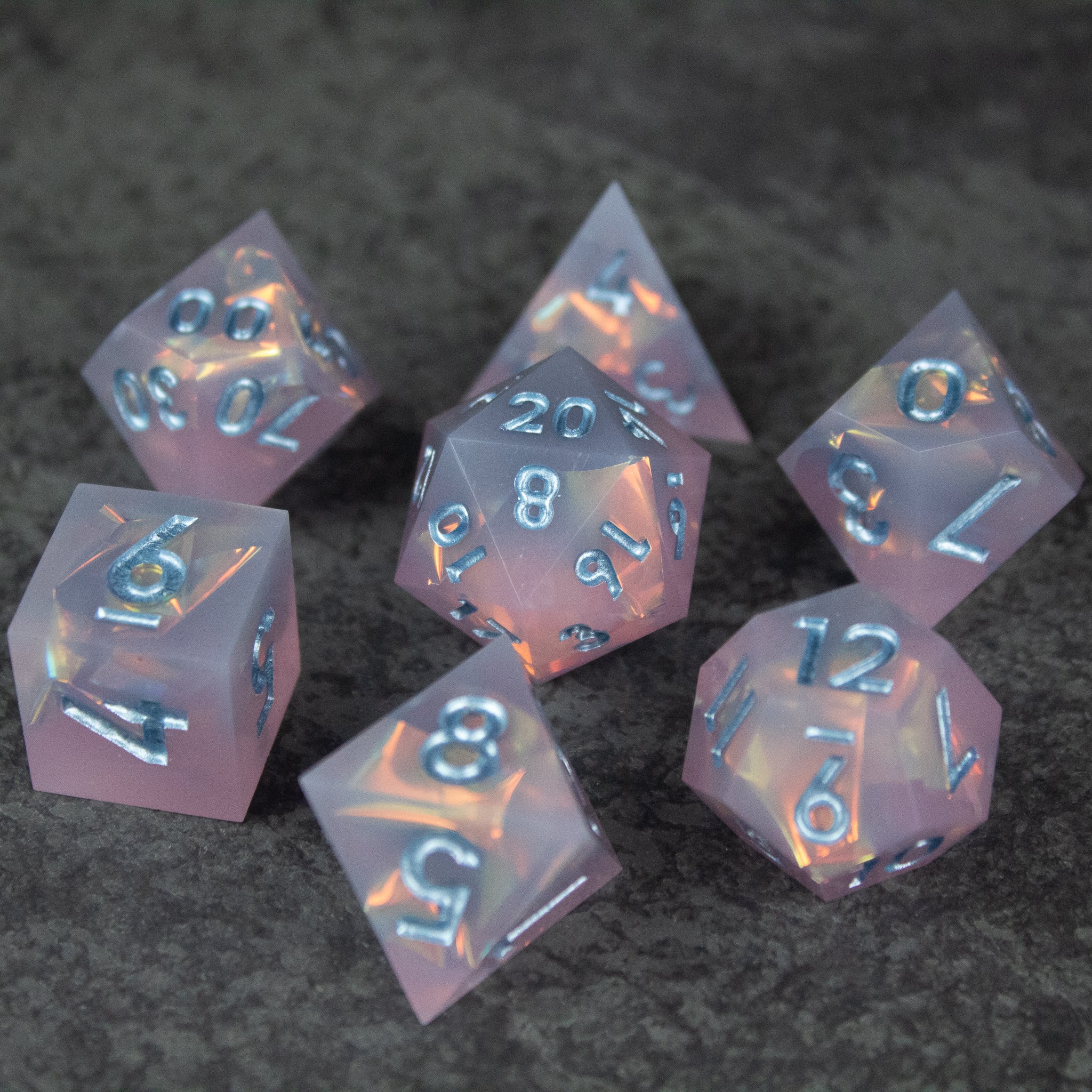 Moonshard Dice Set - Translucent pink sharp-edged polyhedral dice set with metallic silver numbers.