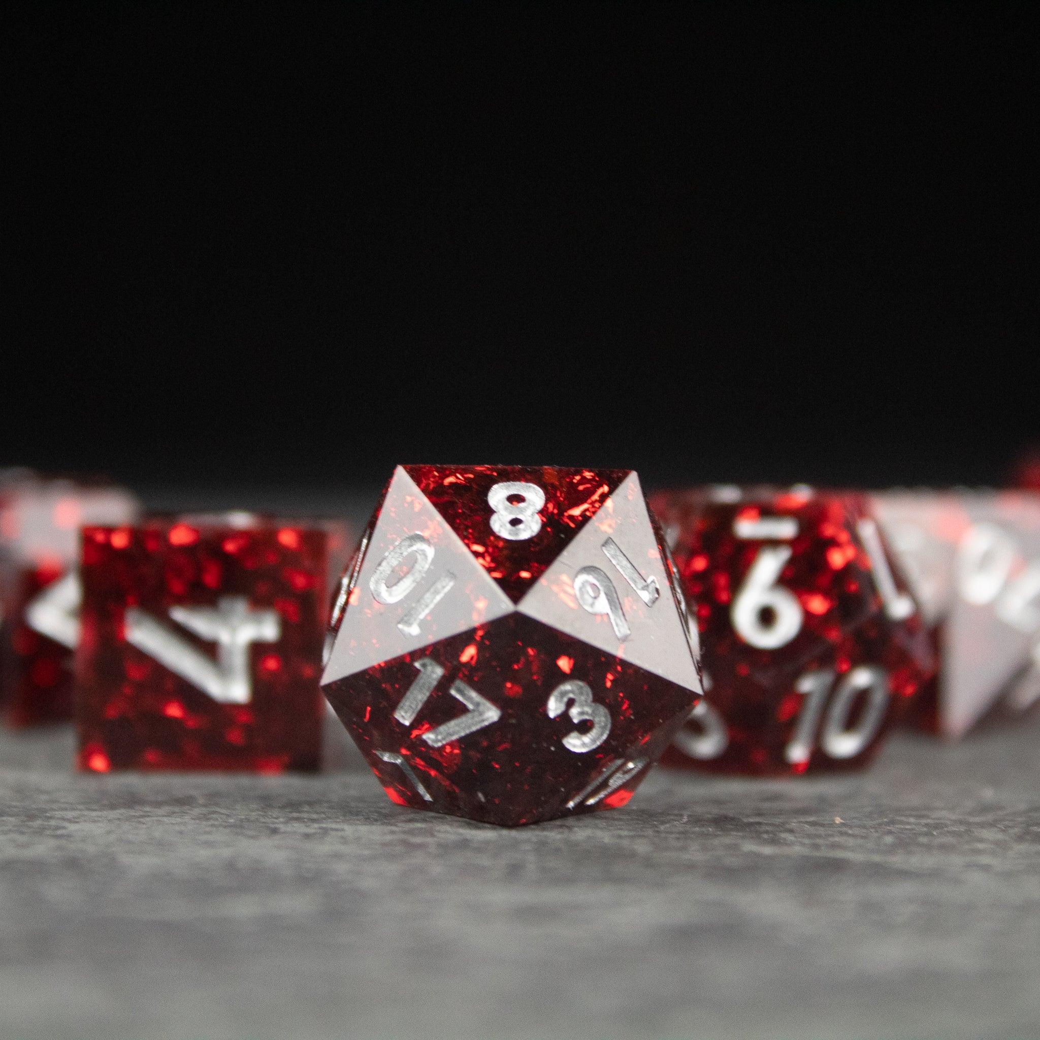 Inferno Dice Set - Red and silver sharp-edged 20-sided dice with clear numbering and glittery finish.
