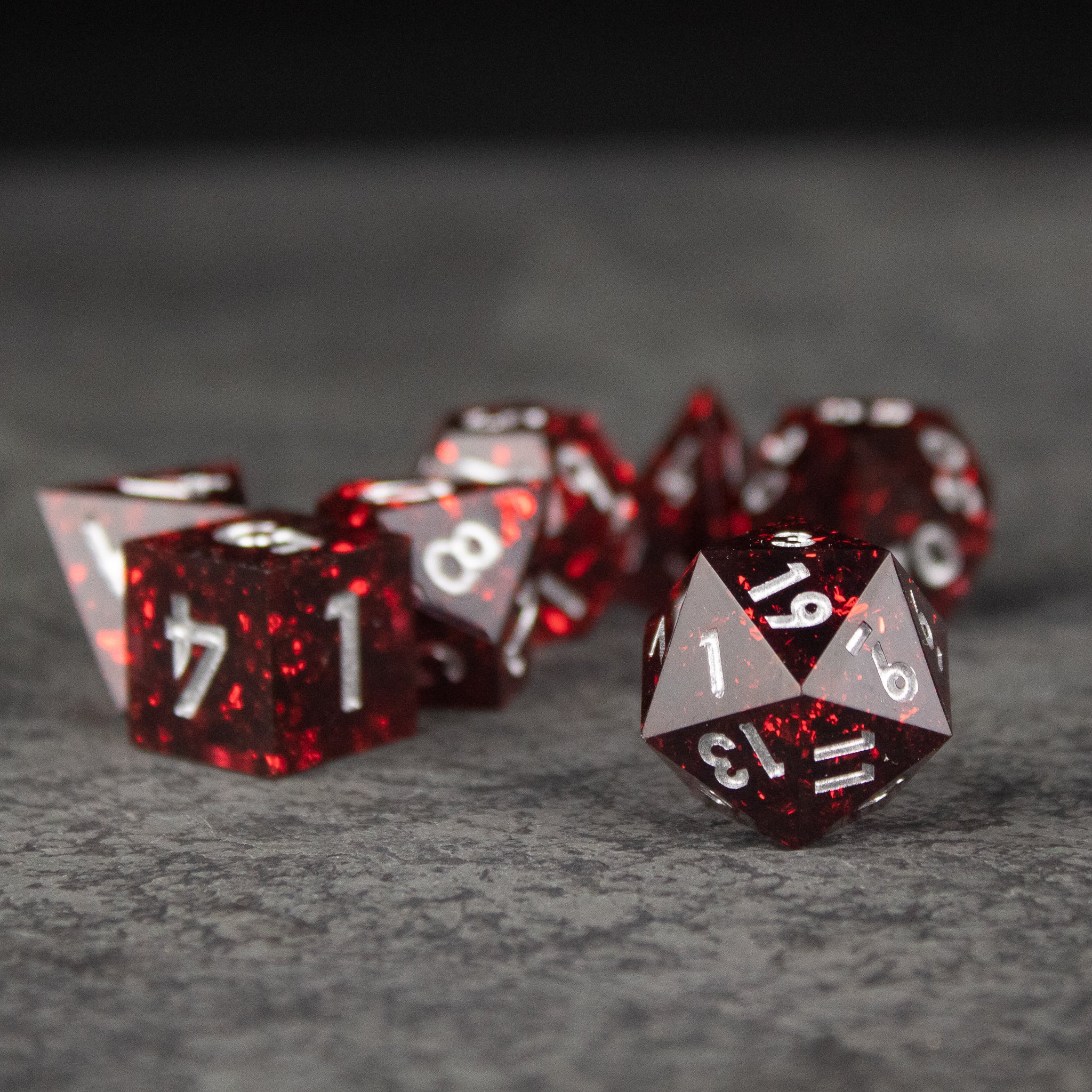 Inferno Dice Set - Glossy red polyhedral dice set with sharp edges and white numbers on each face.