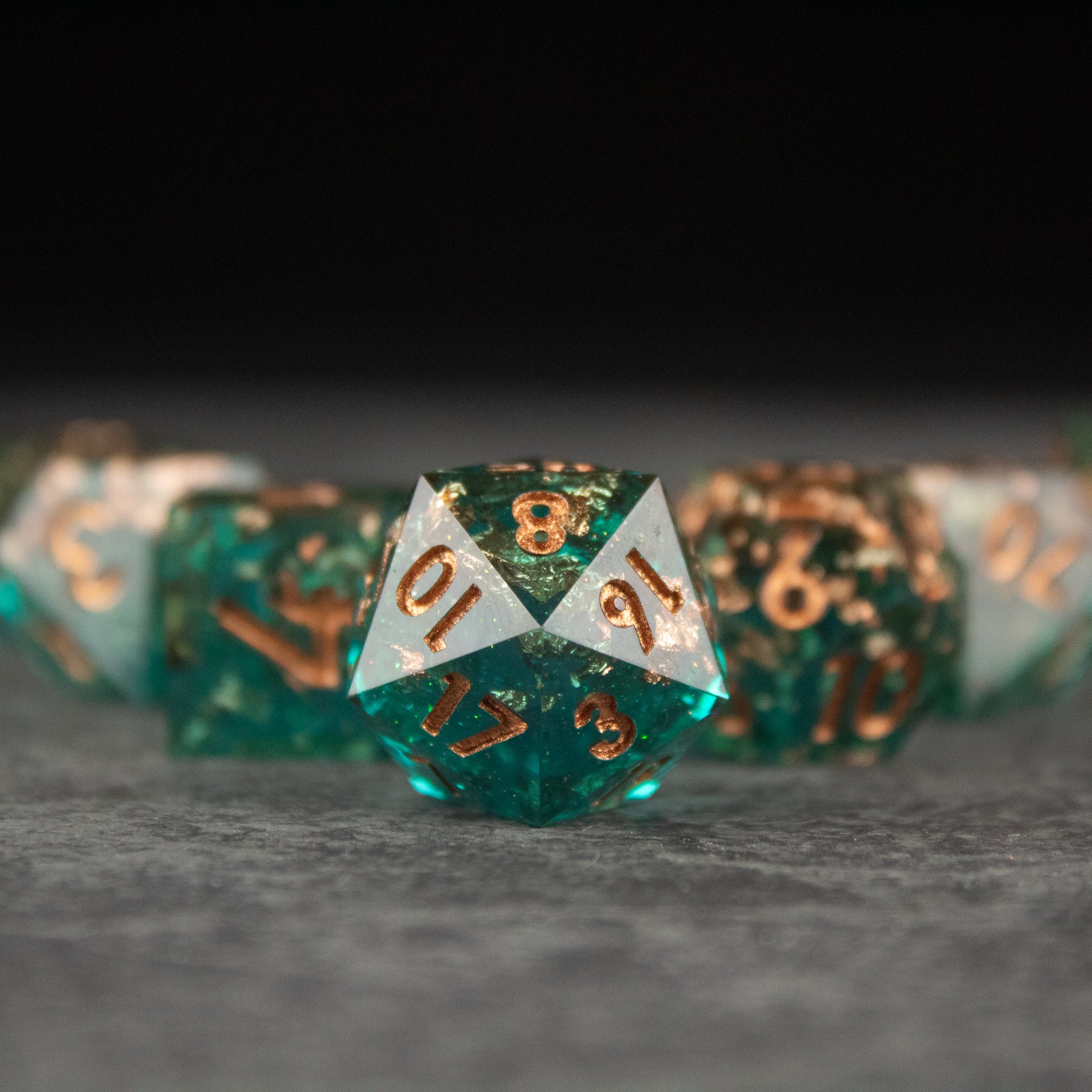 Oasis Dice Set - Green translucent 20-sided dice with sharp edges and gold numbering, central dice in focus.