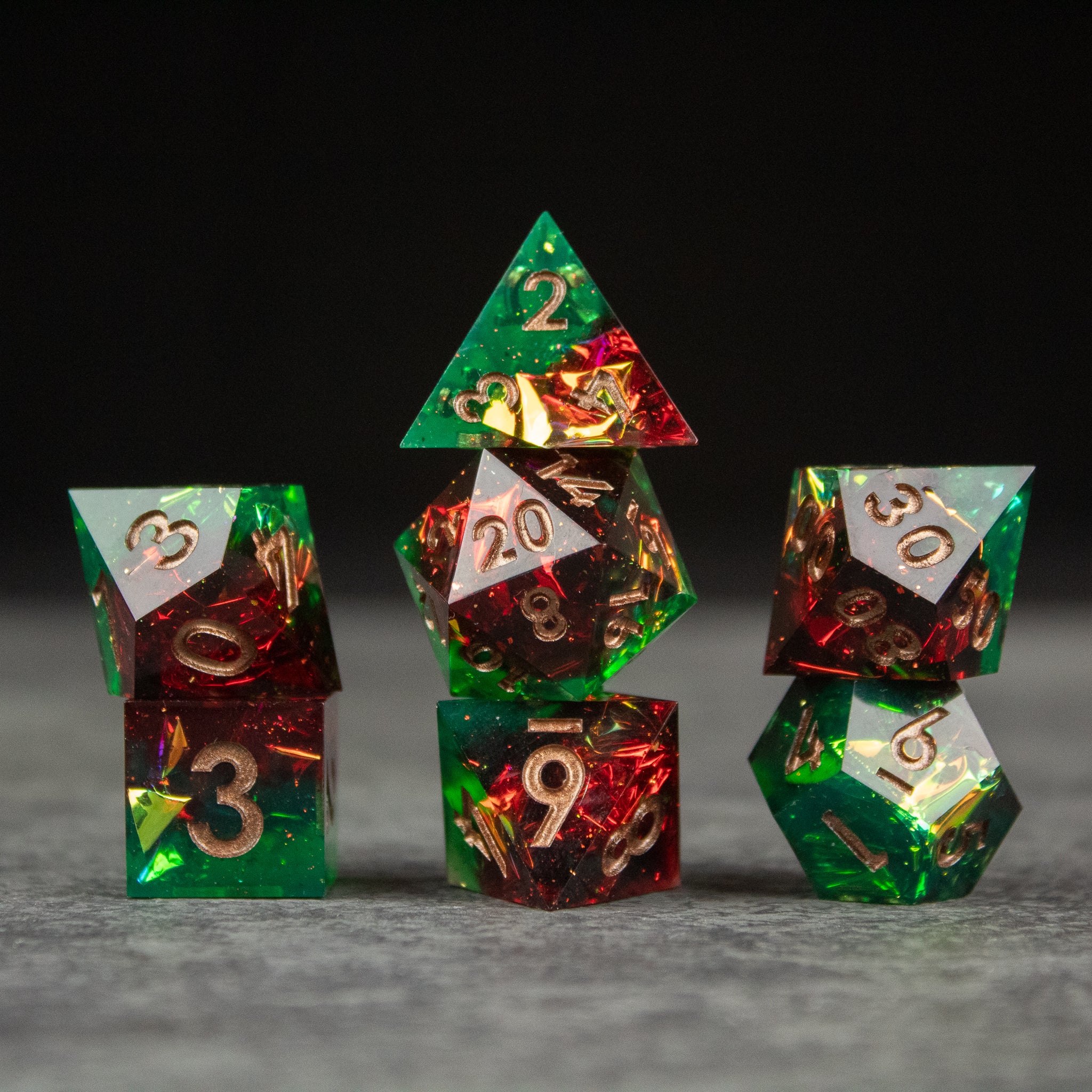 Jungle Fire Dice Set - Set of sharp-edged green and red translucent dice with gold numbering including d20, d12, d10, d8, d6, and d4.
