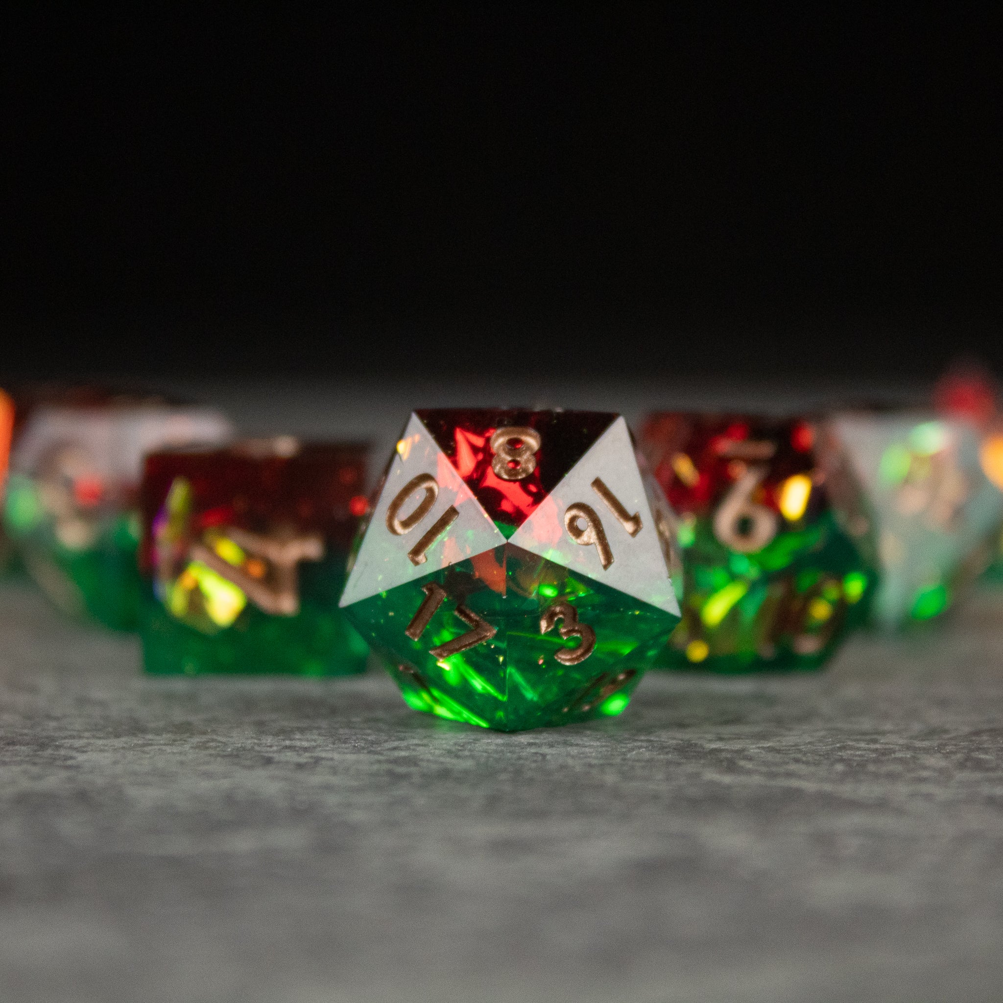 Jungle Fire Dice Set - Multi-colored green and red sharp-edged twenty-sided dice with gold numbering and triangular insets.