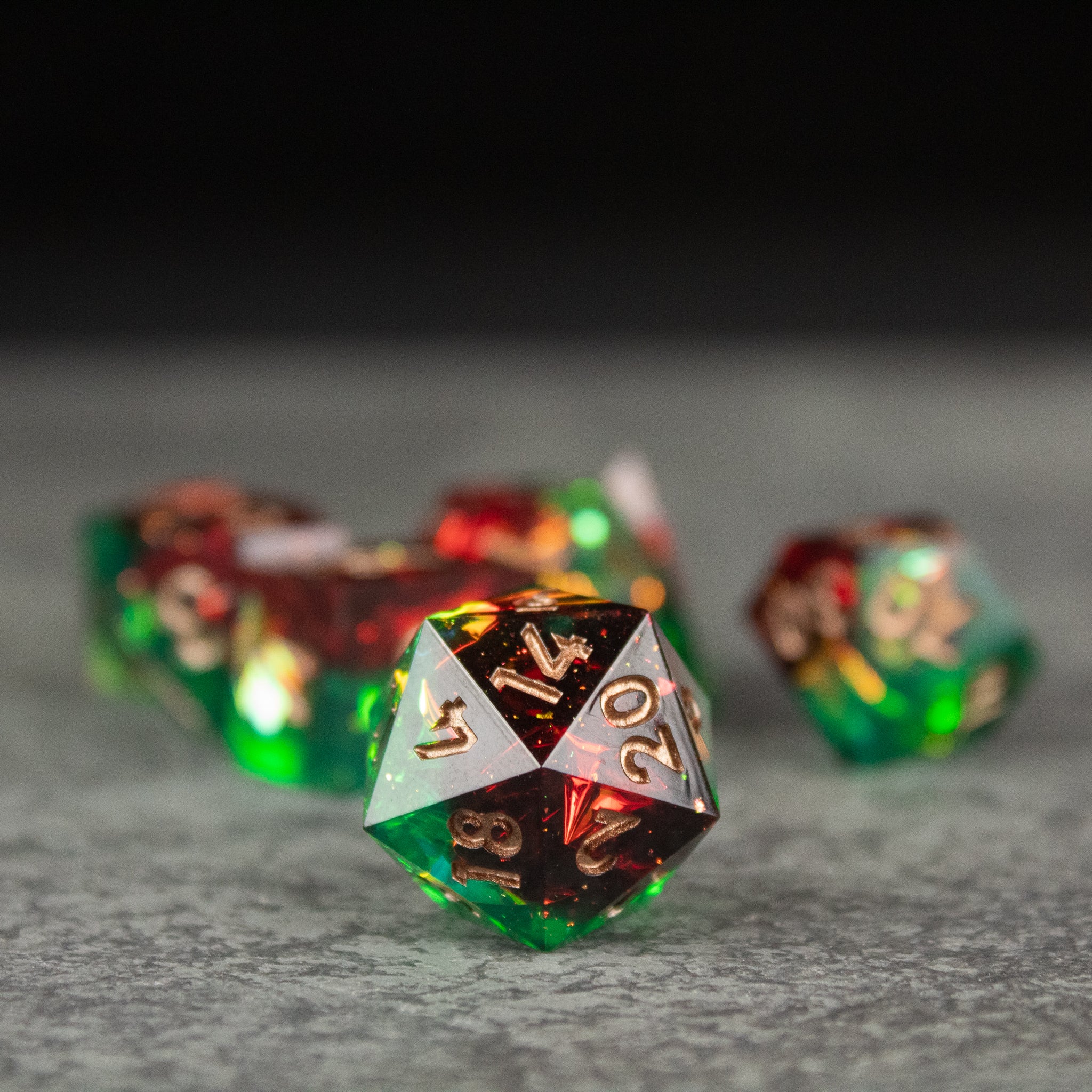 Jungle Fire Dice Set - Green and red translucent sharp-edged polyhedral dice with gold numbering.
