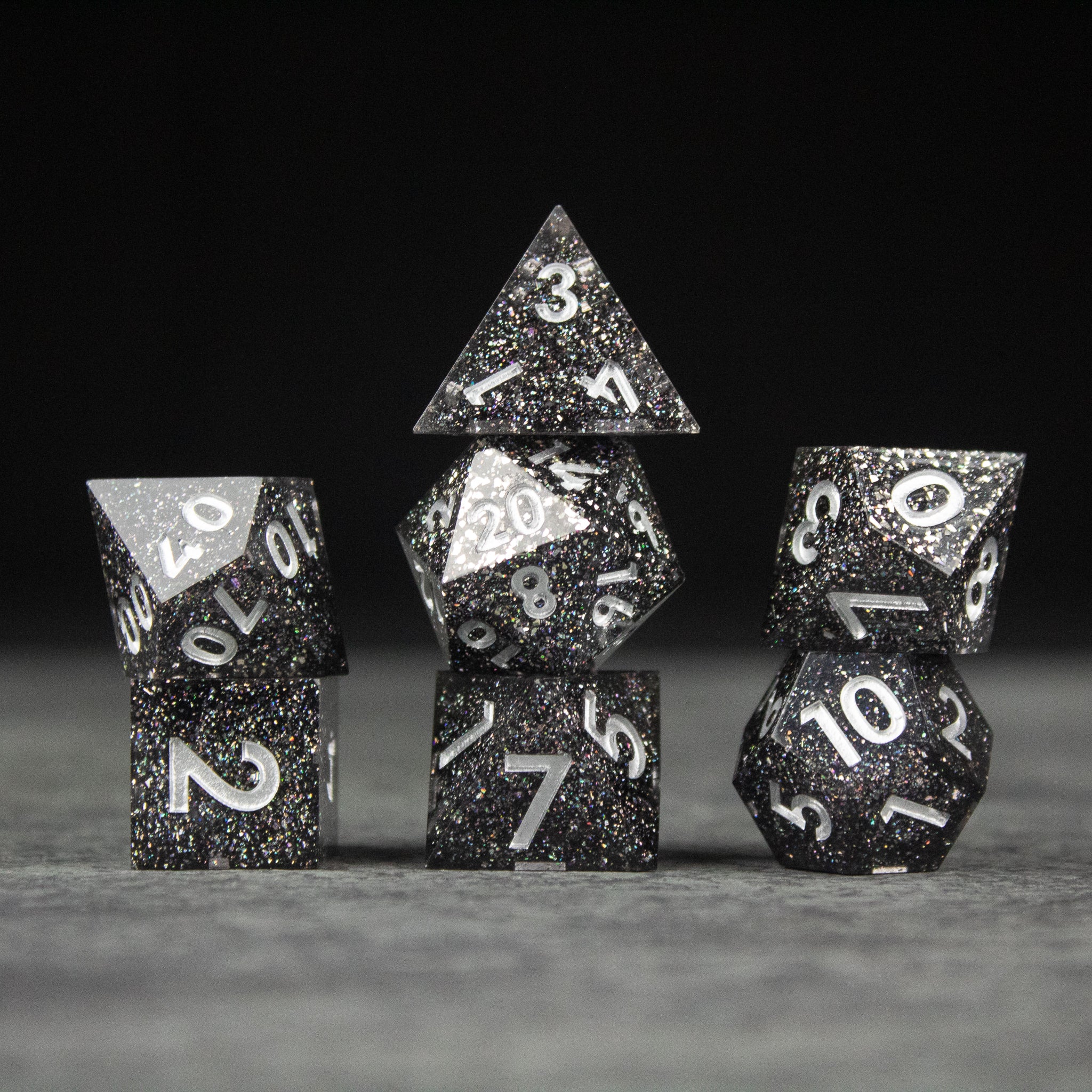 Starfield Dice Set - Black and silver speckled sharp-edged polyhedral dice set with white numbers, including d4, d6, d8, d10, d12, and d20.