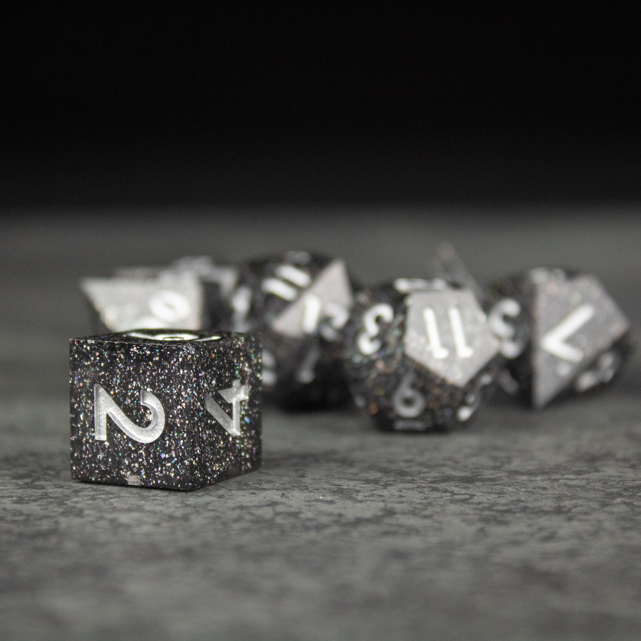 Starfield Dice Set - Black and silver glitter sharp-edged polyhedral dice set with white numbering for tabletop games.