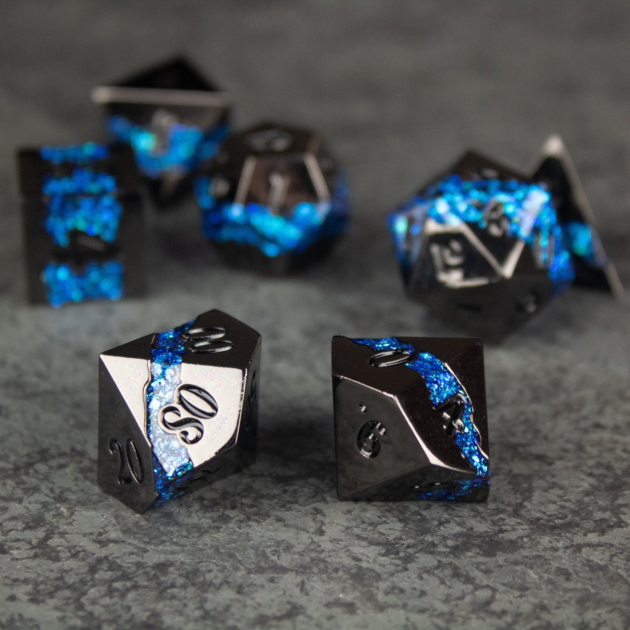 Blue Rift Dice Set - Black metal dice set with glowing blue fissure-like veins and engraved numbers.