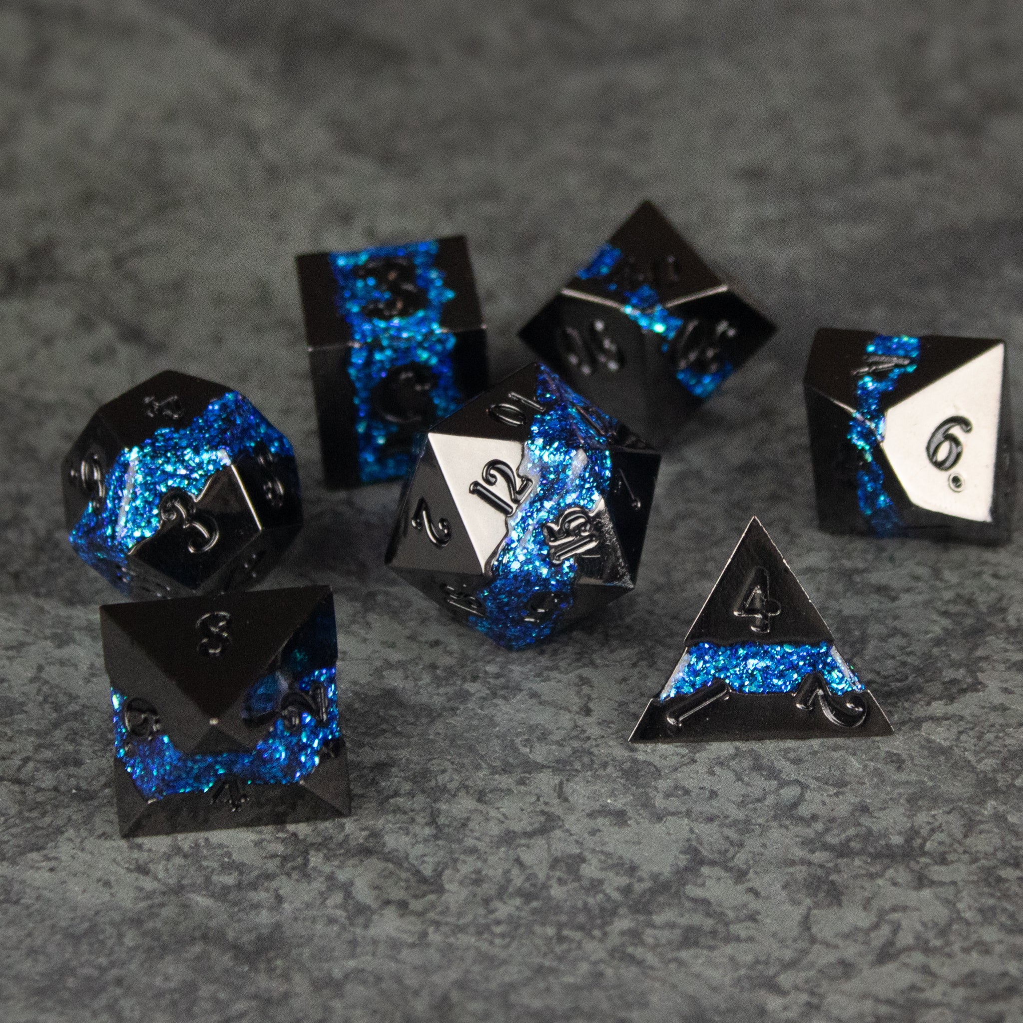 Blue Rift Dice Set - Black and blue metal polyhedral dice set with glowing blue fissure-like patterns and white numbering.