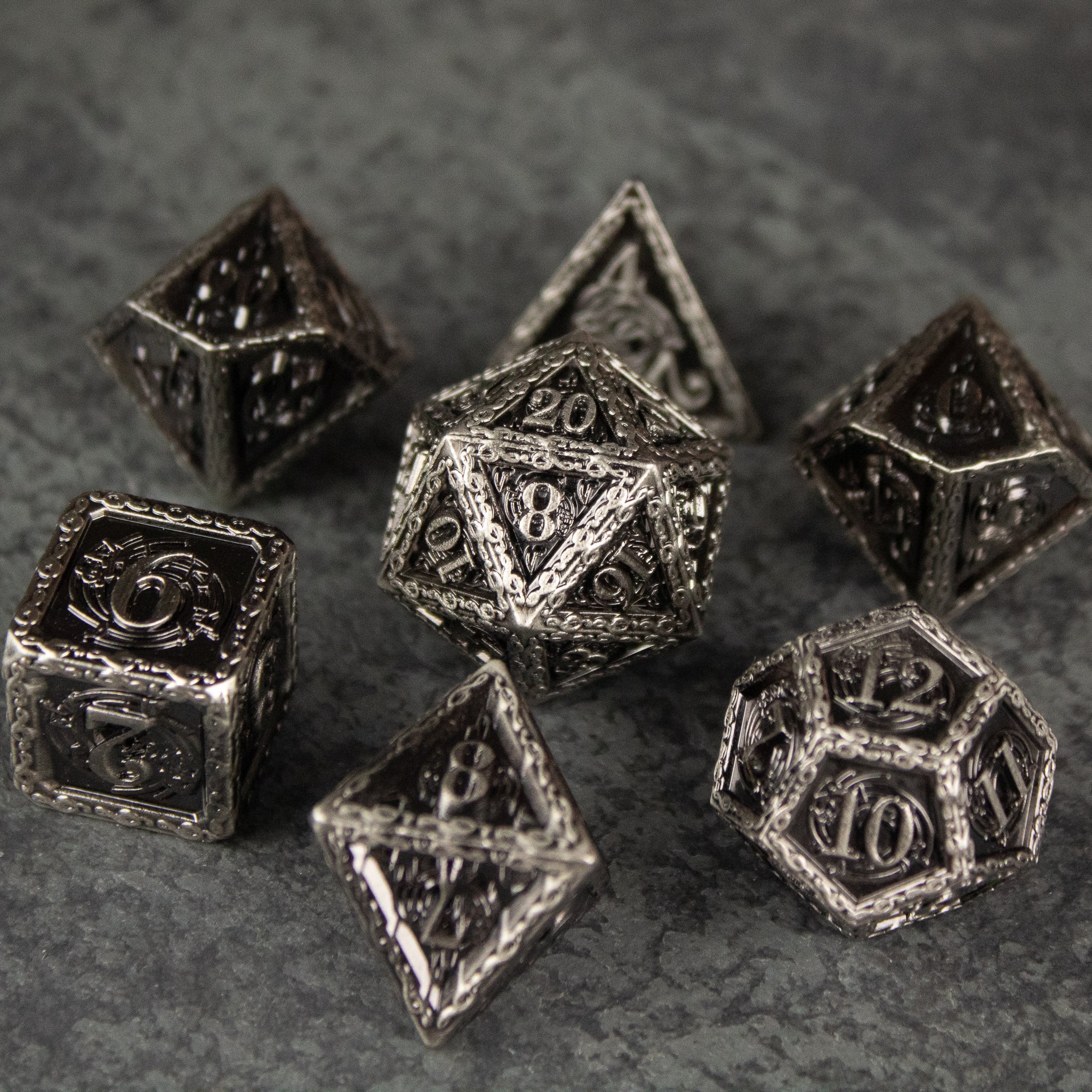 Bardic Inspiration Metal Dice Set - Set of seven metal polyhedral dice with intricate Bardic and musical engravings, silver finish.