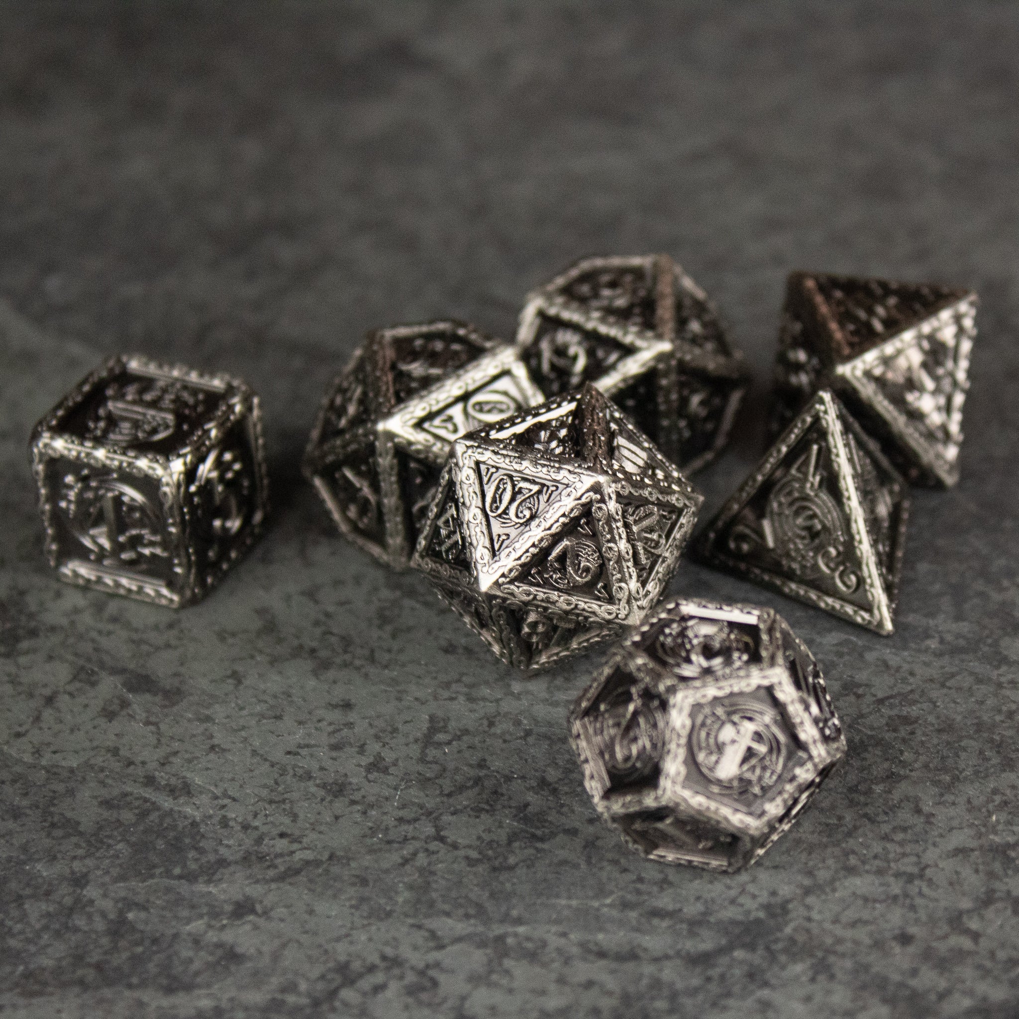 Bardic Inspiration Metal Dice Set - Metal dice set with intricate engraved musical notes and symbols, dark silver finish, including various polyhedral shapes on