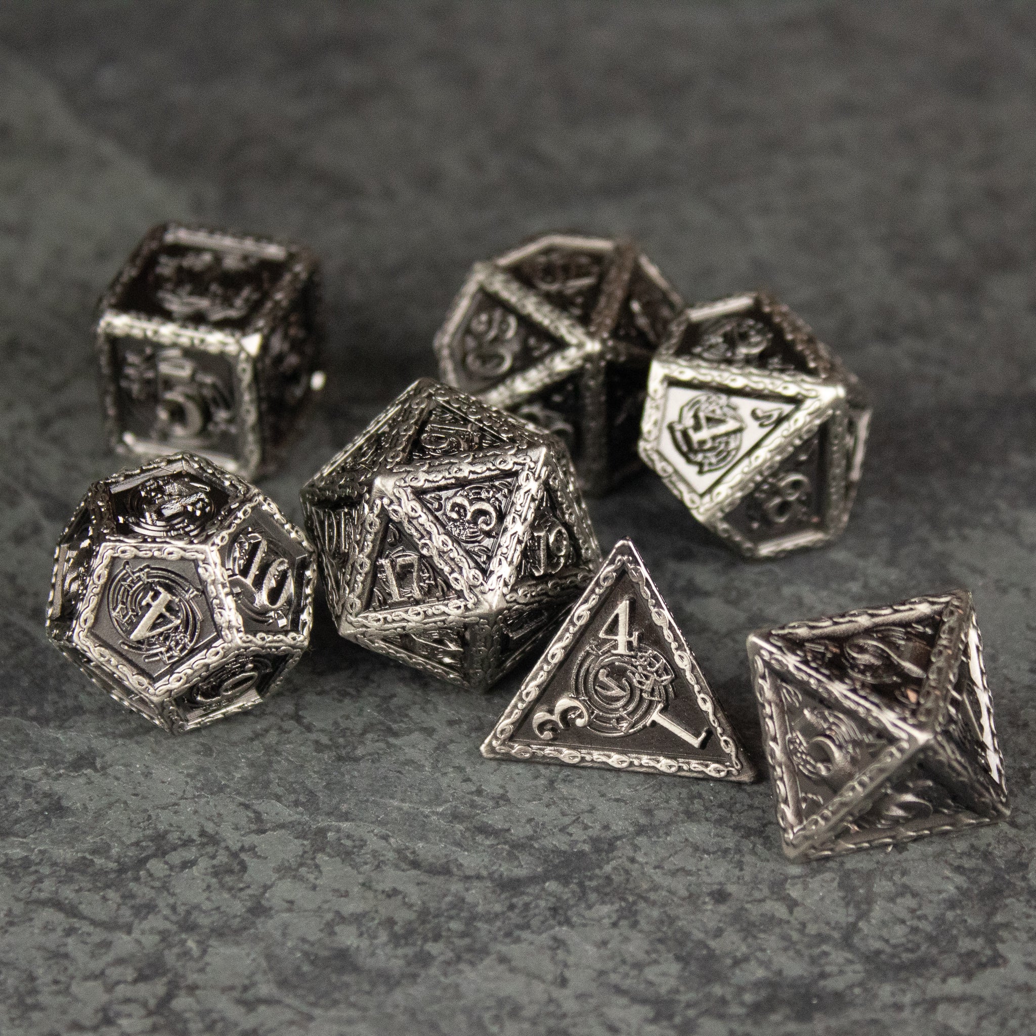 Bardic Inspiration Metal Dice Set - Set of eight silver metal polyhedral dice with intricate engraved designs and musical note motifs.