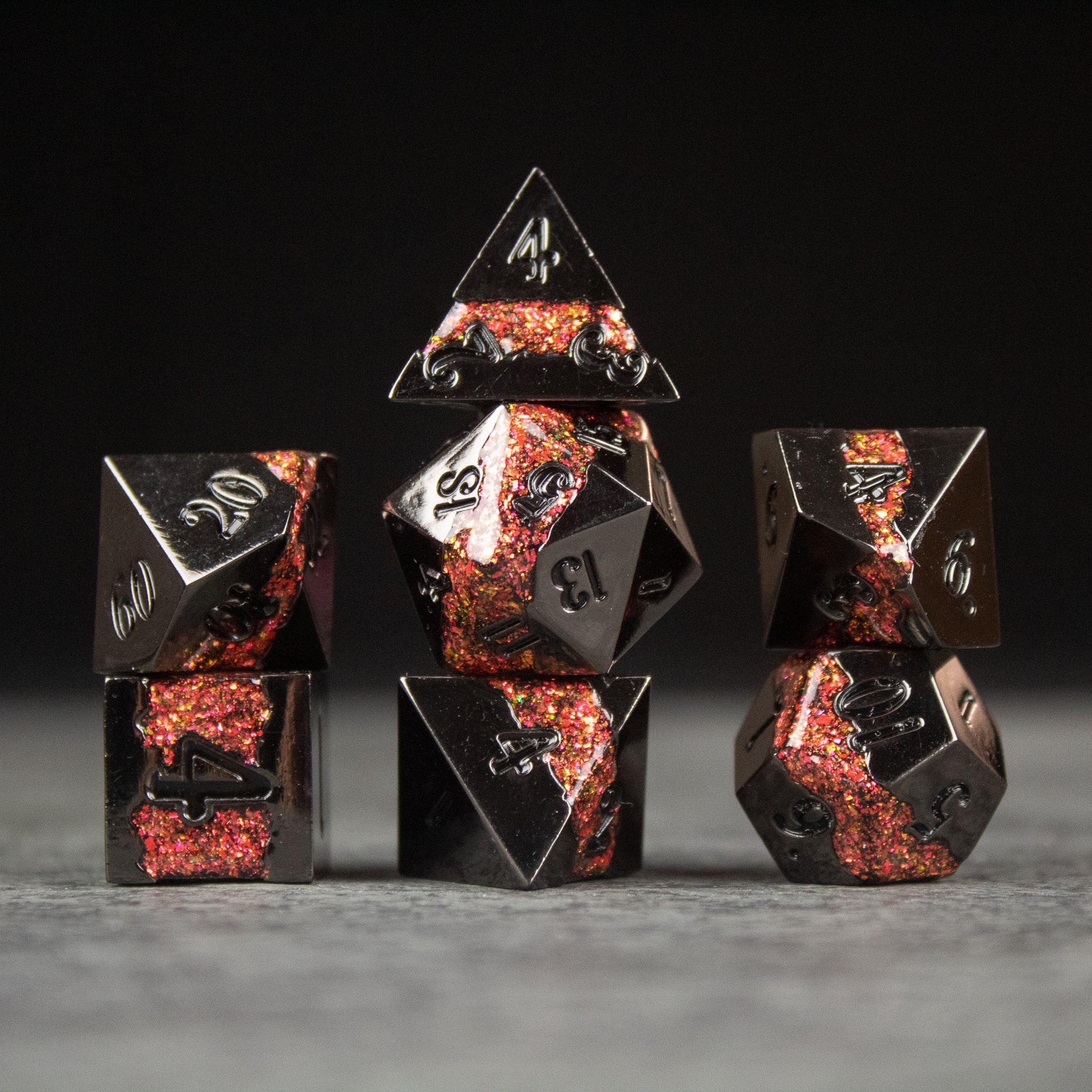 Red Rift Metal Dice Set - Set of seven red and black metal polyhedral dice with silver numbering, featuring a fiery molten design.