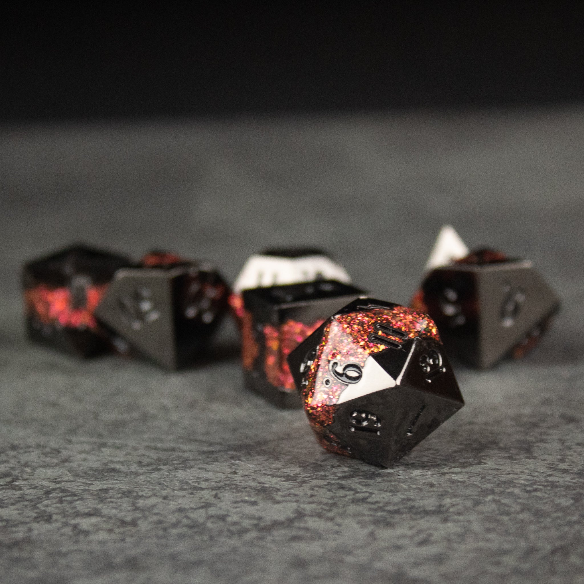 Red Rift Metal Dice Set - Set of black metal polyhedral dice with red molten lava-like accents and engraved white numbers.