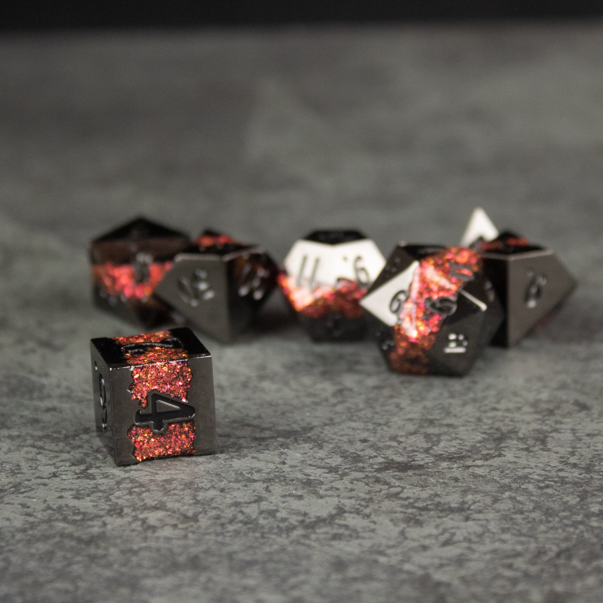 Red Rift Metal Dice Set - Black and red metal dice set with glowing red crack patterns, featuring various polyhedral shapes including a d6 cube and.