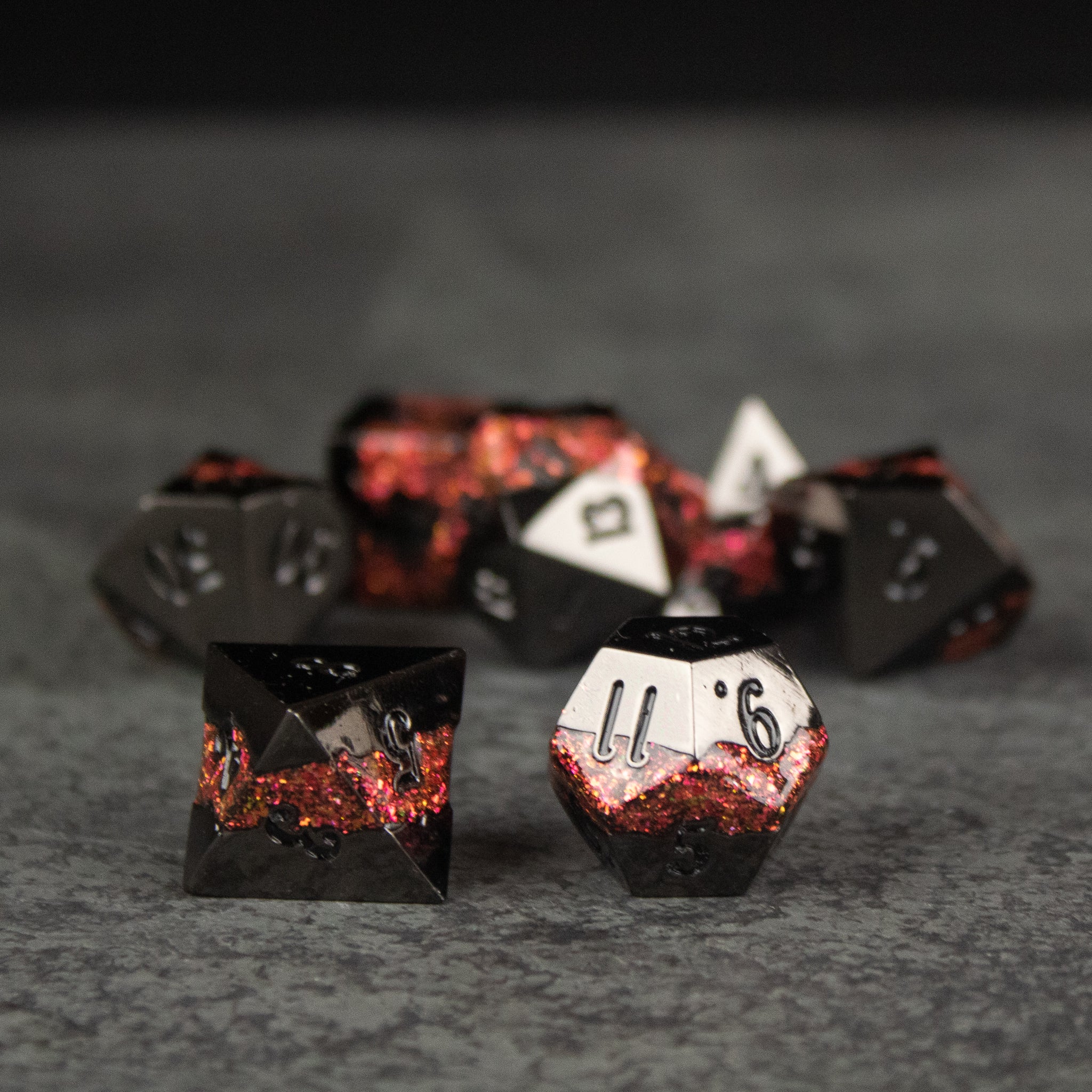 Red Rift Metal Dice Set - Set of red and black metal dice with sharp edges and engraved white numbers, designed for tabletop gaming.