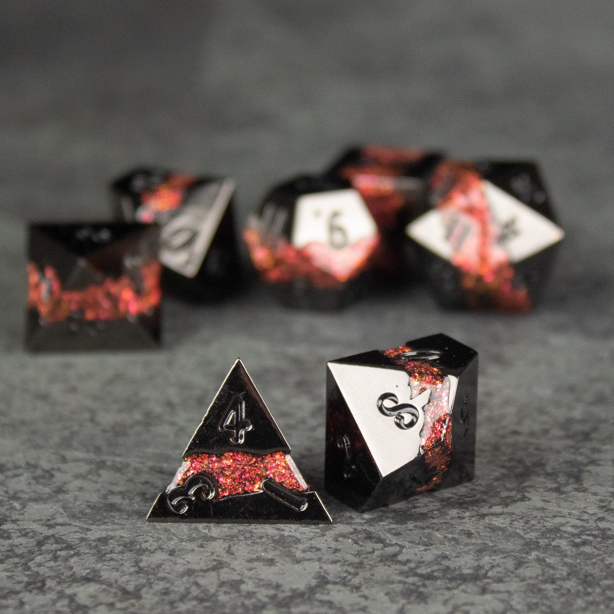 Red Rift Metal Dice Set - Set of red and black metal polyhedral dice with silver numbers, featuring a fiery crackled design and sharp edges.