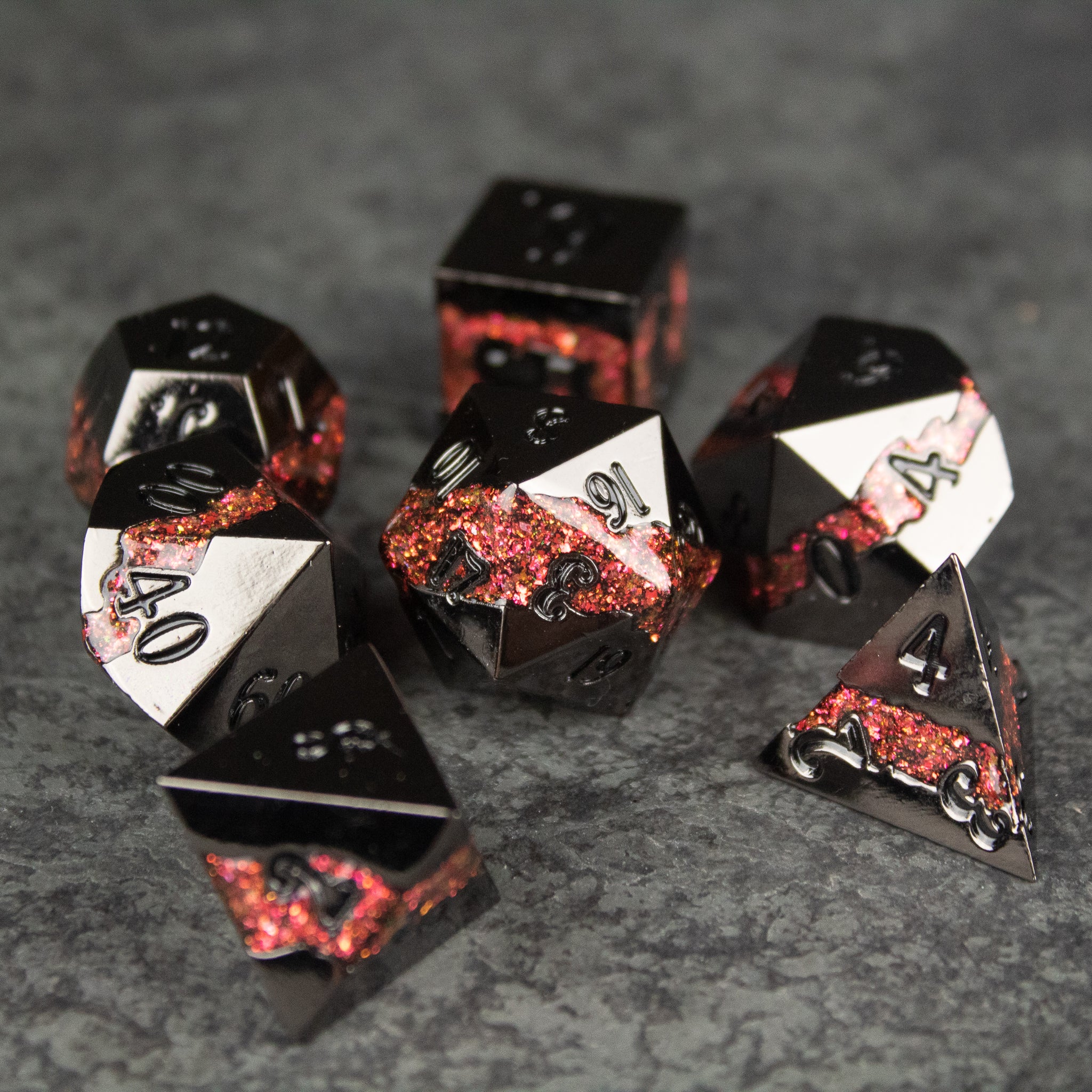 Red Rift Metal Dice Set - Set of seven black and red metal RPG dice with white numbering and fiery red crystalline details.
