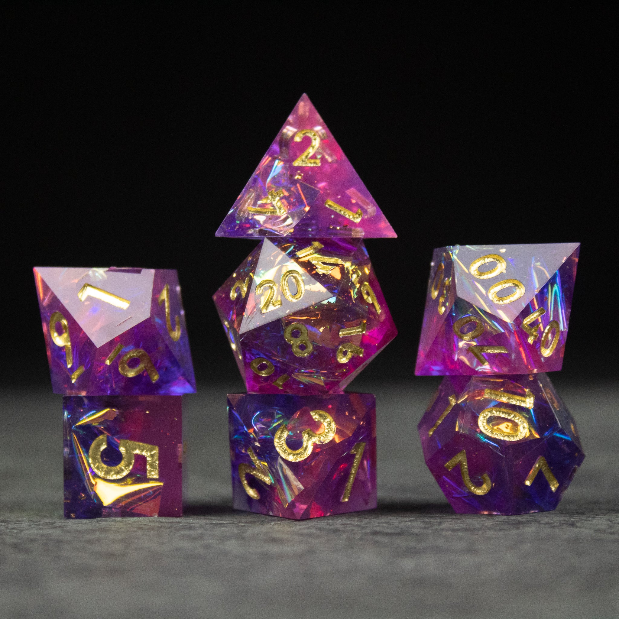 Aether Dice Set - Purple and pink sharp-edged polyhedral dice set with gold numbers, including d20, d12, d10, d8, d6, and d4.