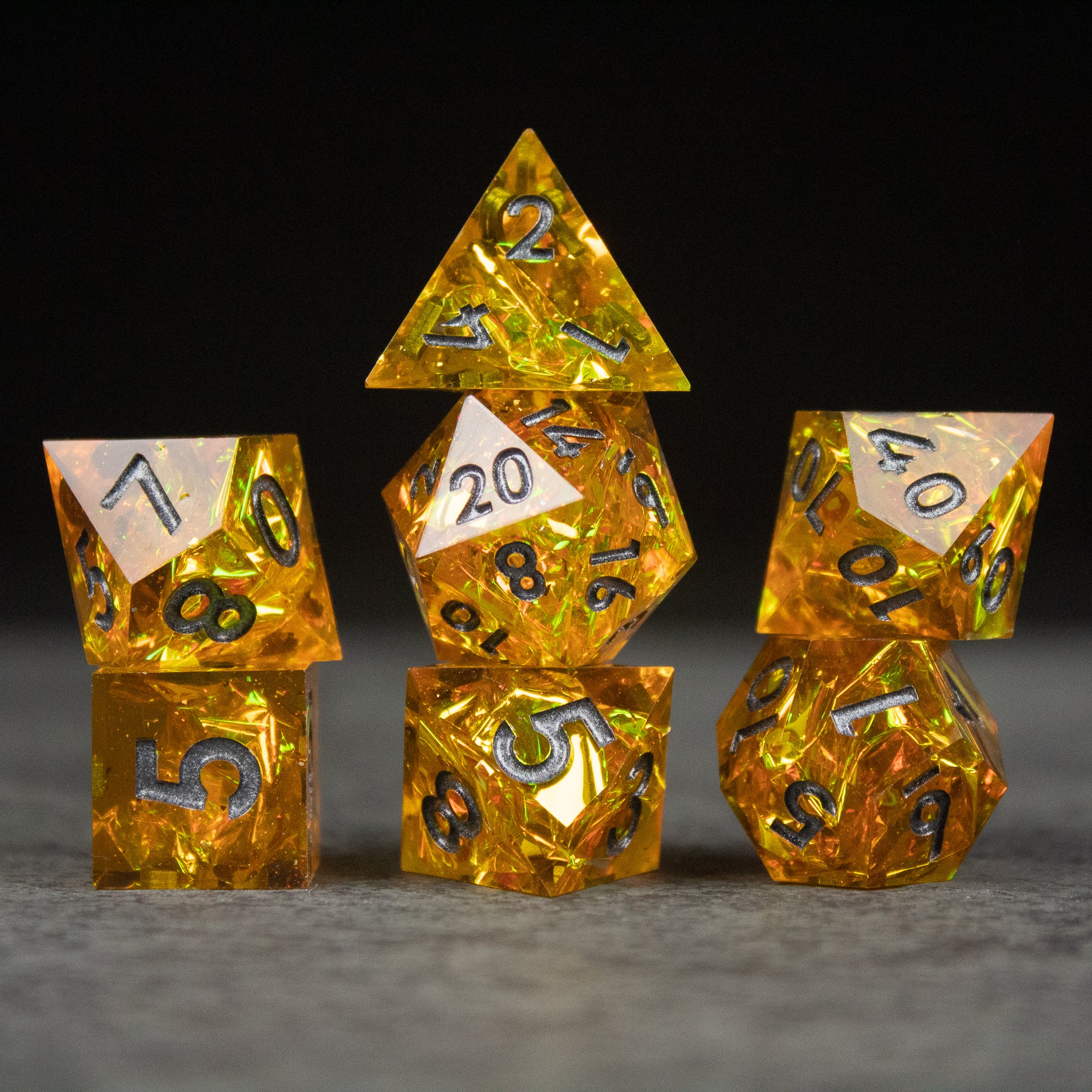 Golden Order Dice Set - Seven translucent golden yellow polyhedral dice with black numbers displayed on a gray surface.