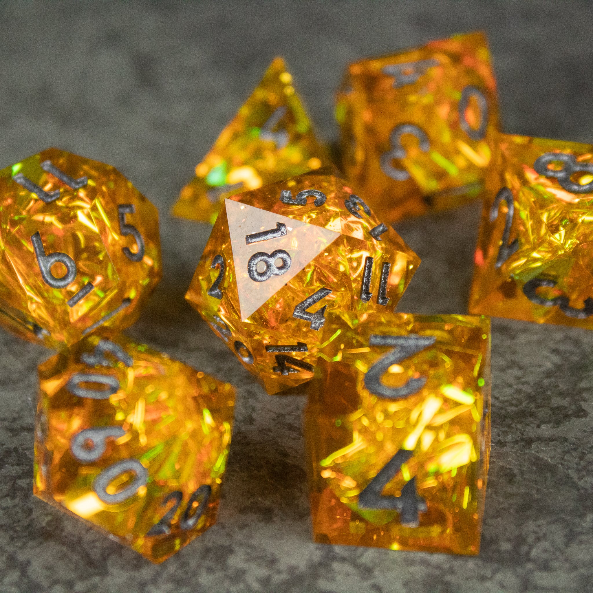 Golden Order Dice Set - Set of translucent golden yellow polyhedral dice with sharp edges and black numbering, featuring a 20-sided die prominently.