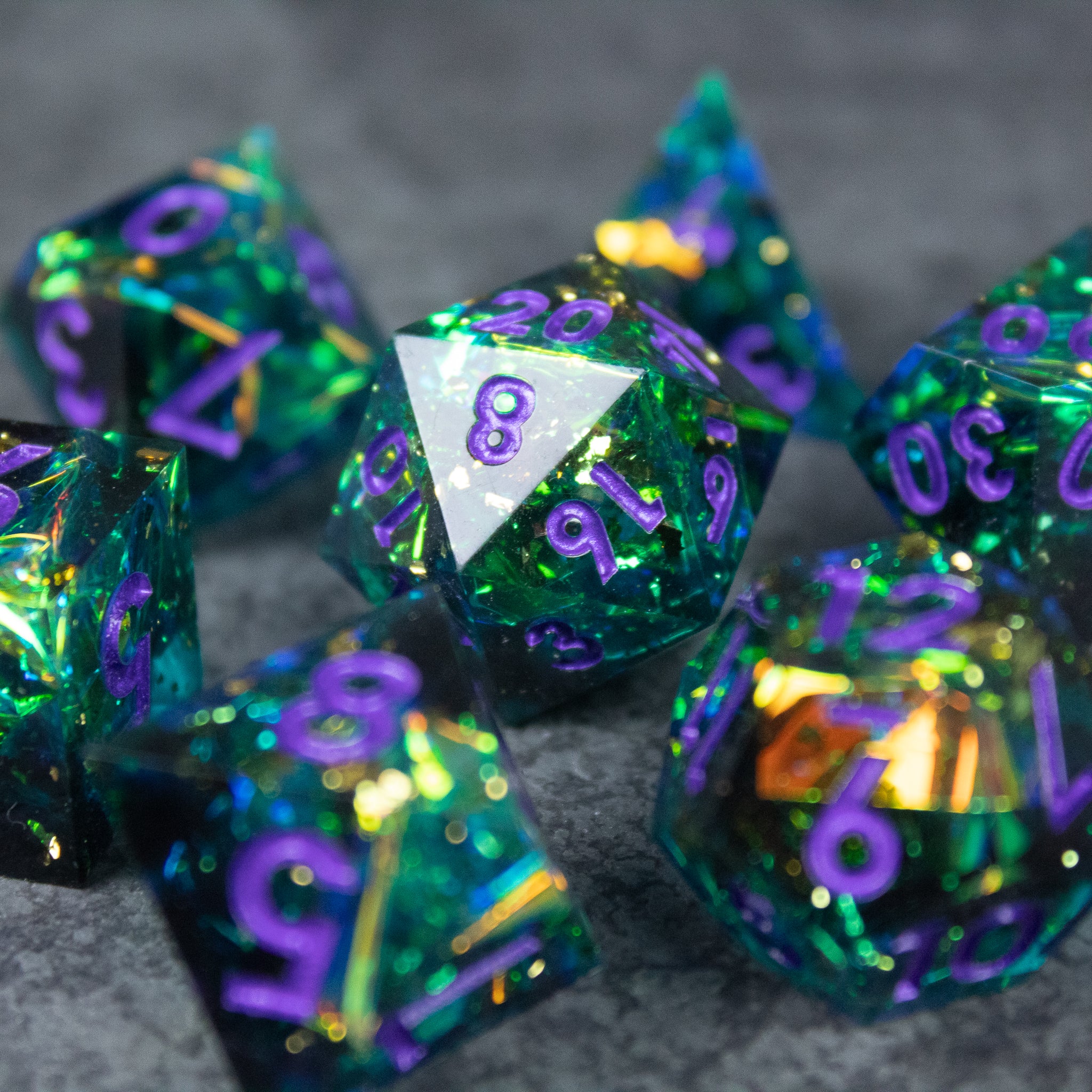 Deathblight Dice Set - Set of translucent green and blue polyhedral dice with purple numbers and sharp edges, including a silver 20-sided die with.