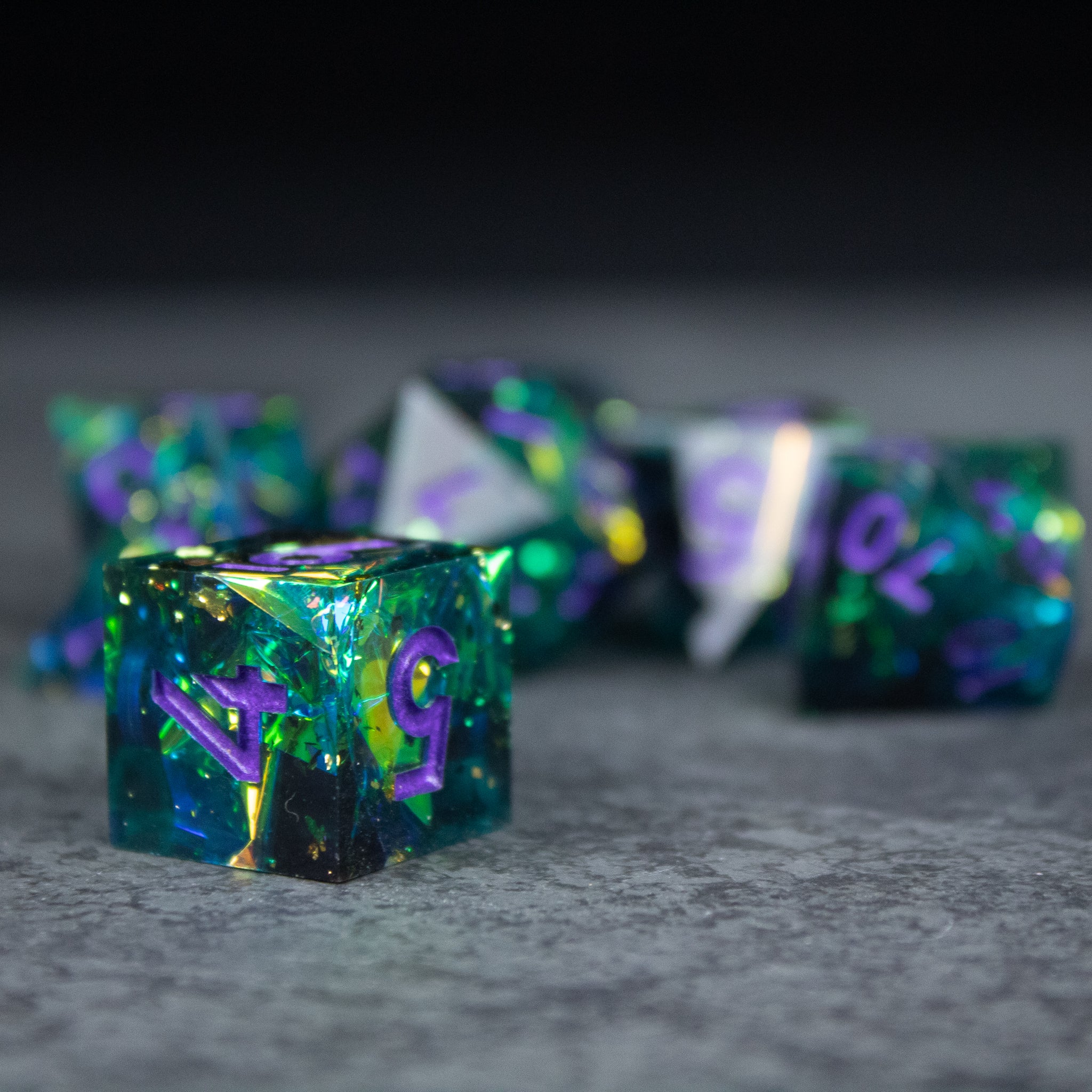 Deathblight Dice Set - Translucent blue-green sharp-edged dice with purple numbering and gold flecks, multi-sided set.
