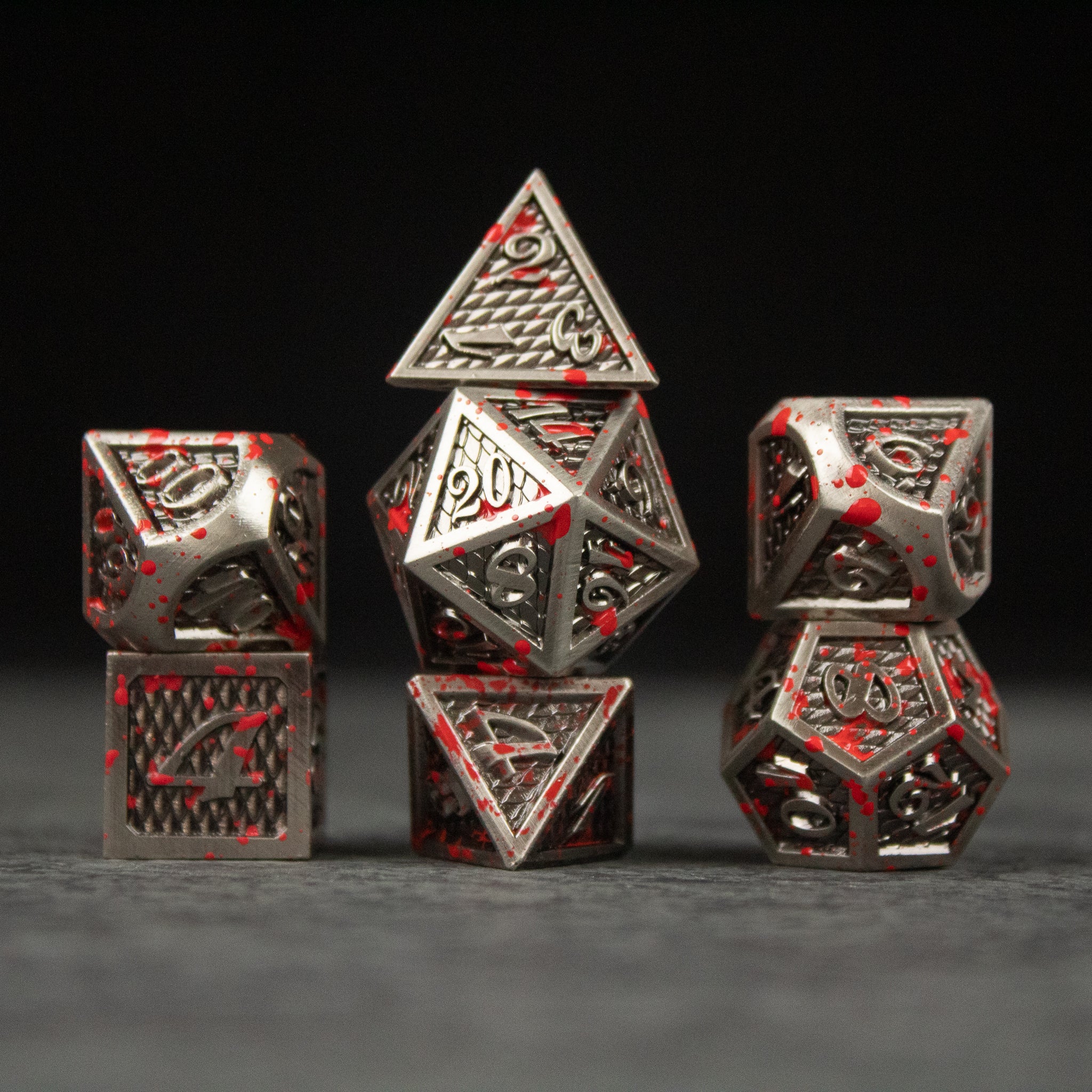 Marauder Dice Set - Metal Marauder dice set with intricate designs and red accents on black background.