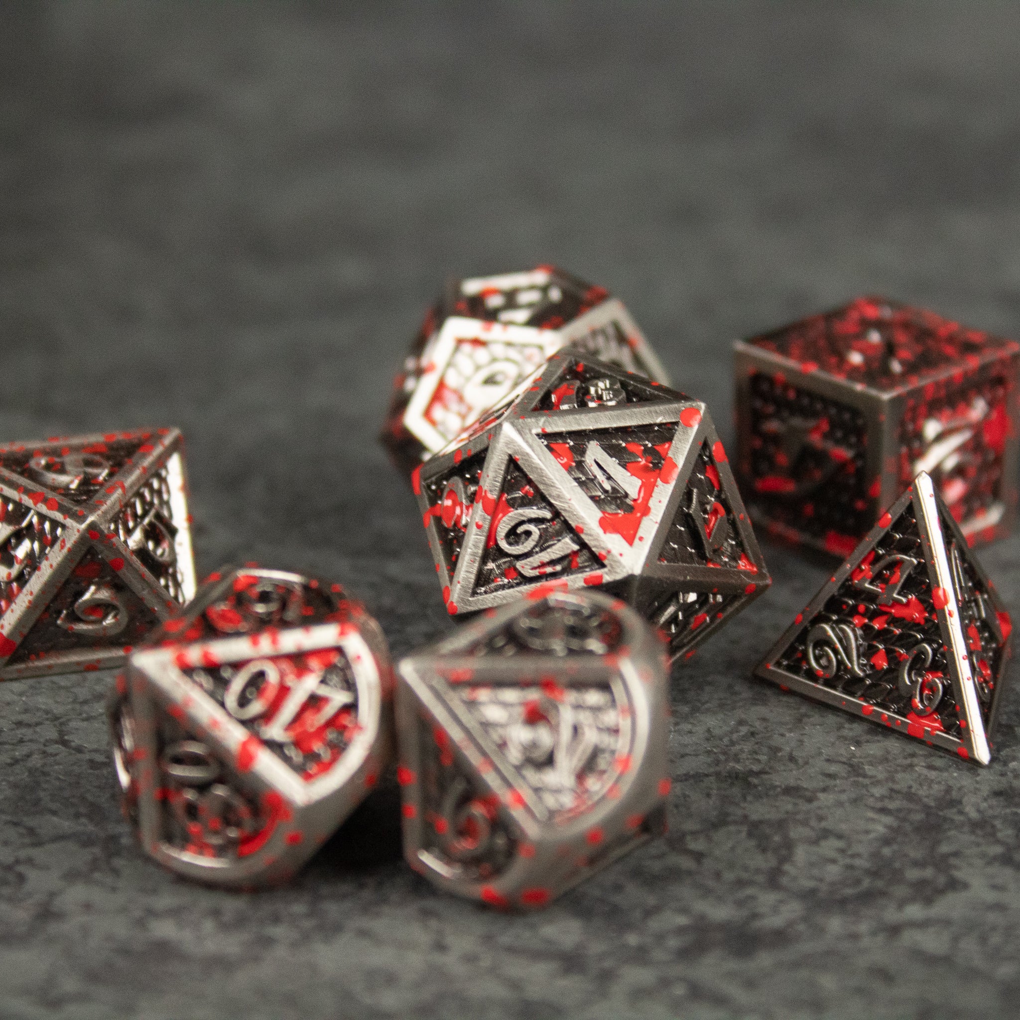 Marauder Dice Set - Metallic black and red polyhedral dice set with intricate angular cutouts and bold numbers.