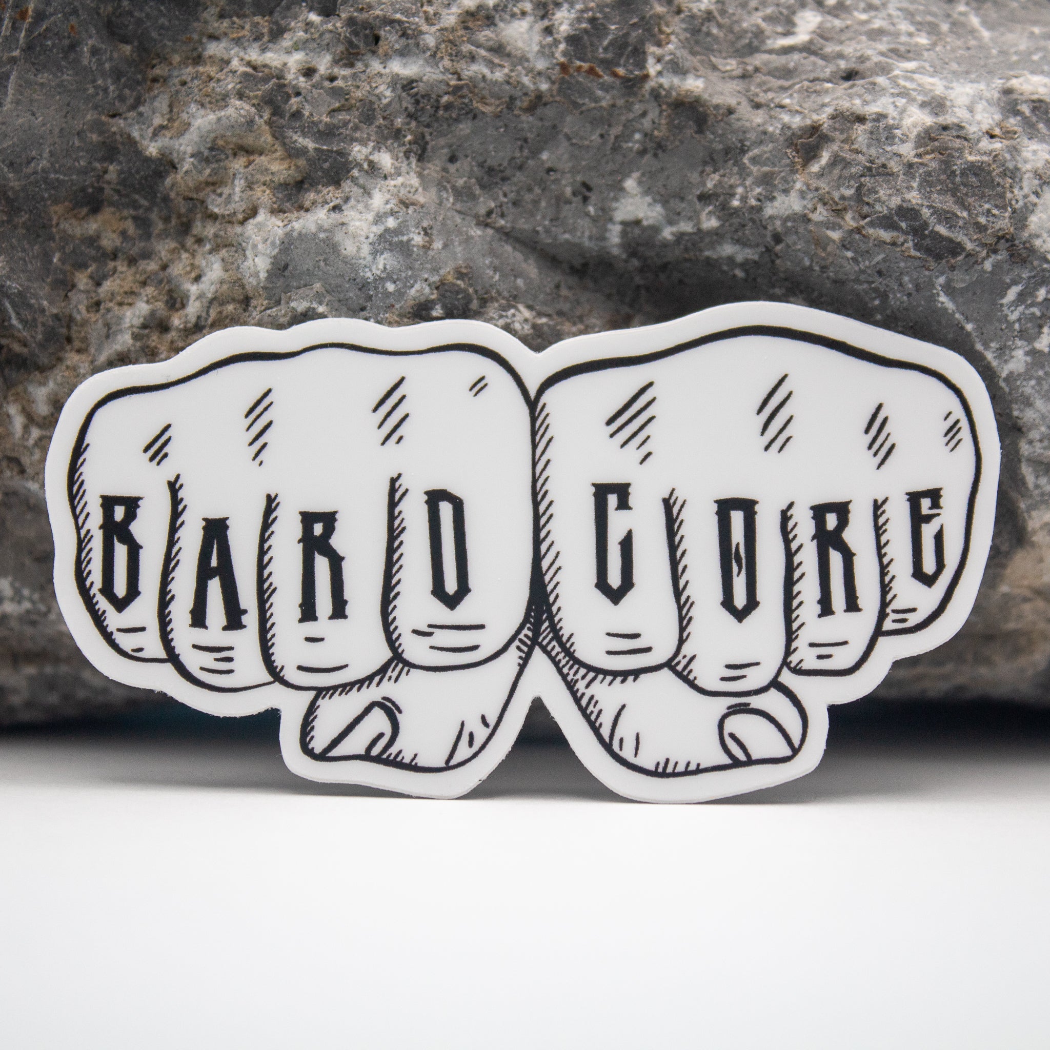 Bardcore DnD Sticker - Sticker of two fists side by side with "BARD" and "CORE" tattooed across the knuckles in bold black letters.