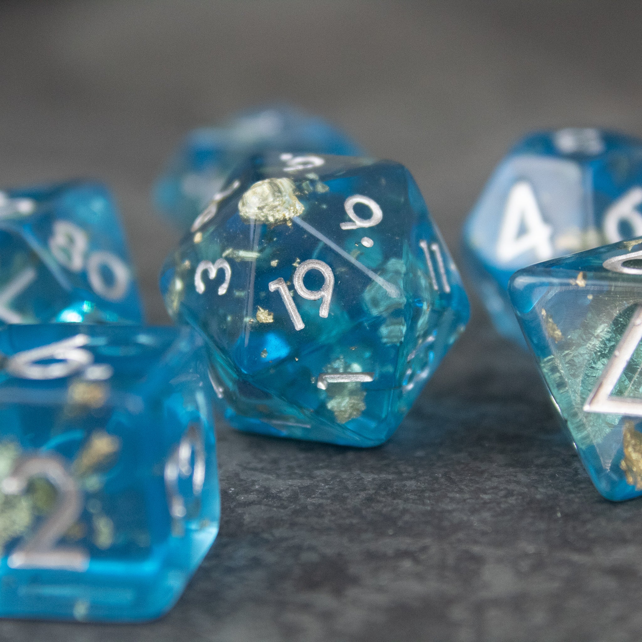Blue Foil Dice Set - Set of blue translucent 20-sided dice with silver foil numbers and glitter accents.