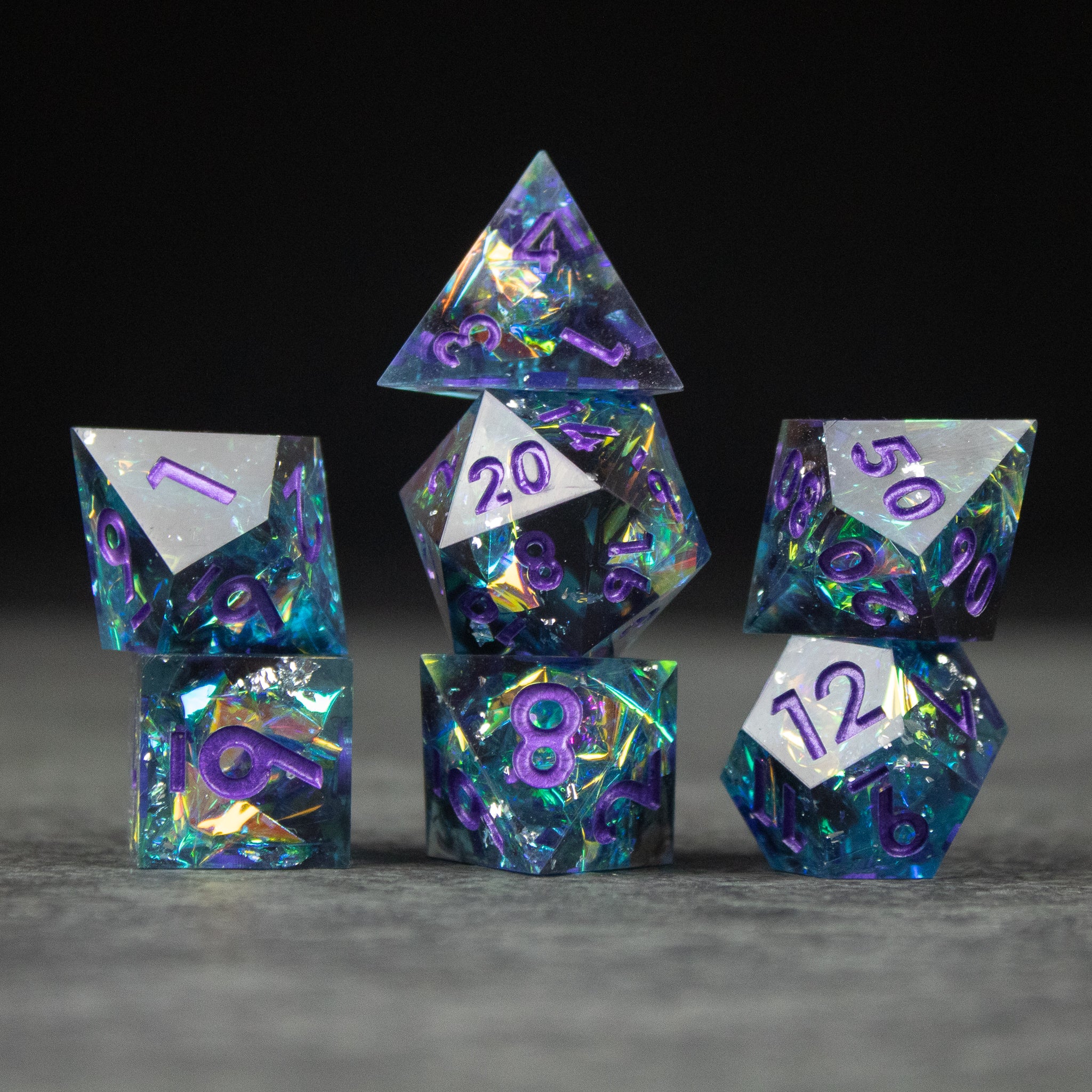 Frostbite Dice Set - Set of seven sharp-edged dice with black, blue, and purple marbled interiors and white numbering.