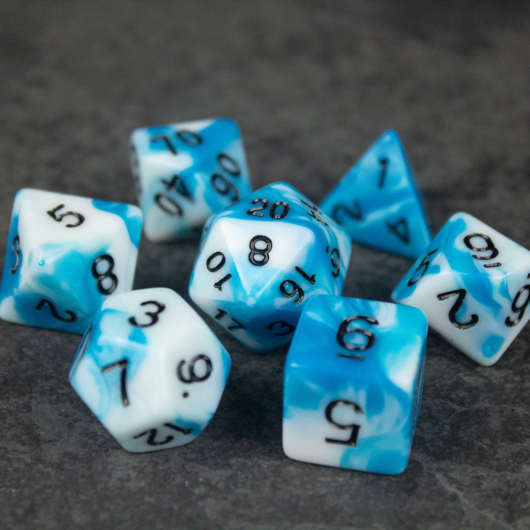 Blue and White Marbled Dice Set - Set of blue and white marbled acrylic dice with black numbers on dark background.
