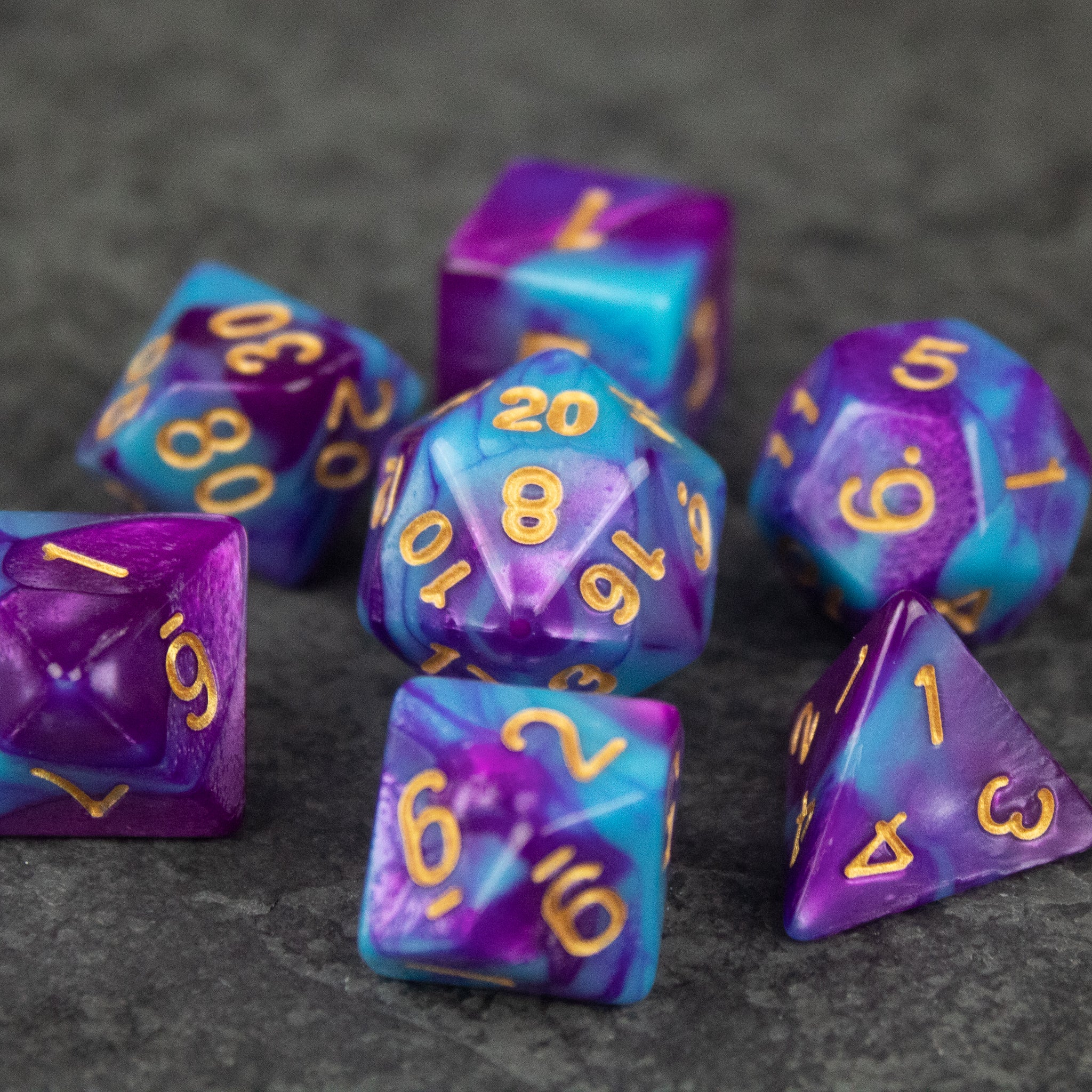 Purple and Blue Marbled Dice Set - Set of seven acrylic dice with purple and blue marbled patterns and gold numbers.