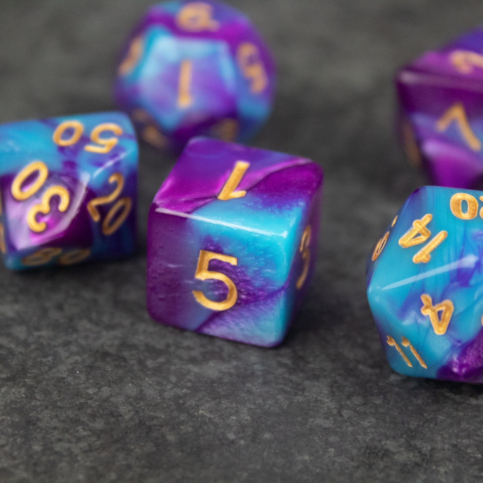 Purple and Blue Marbled Dice Set - Set of acrylic dice with a purple and blue marbled design and gold numbering.