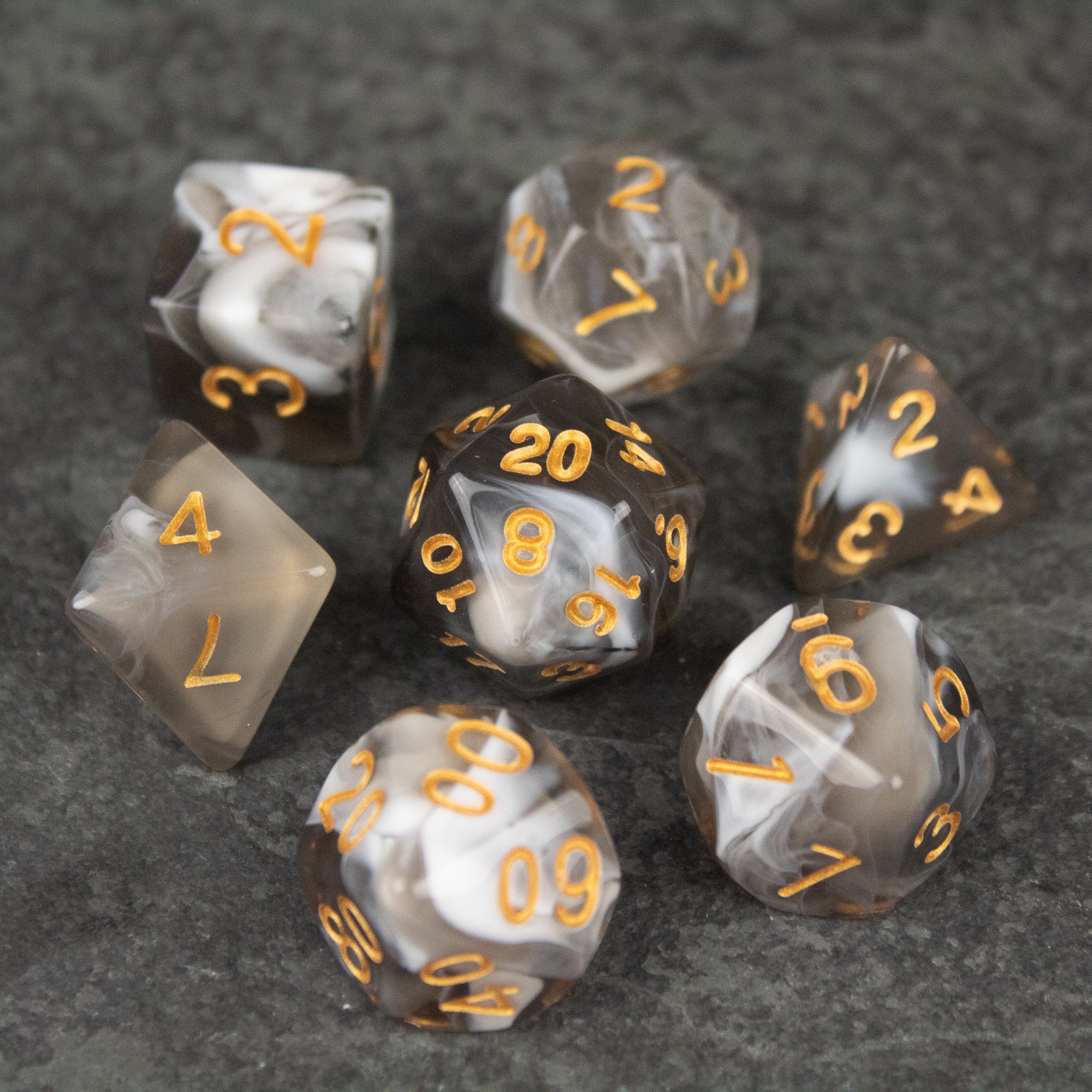 White and Gray Marbled Dice Set - White and gray marbled acrylic dice set with gold numbers on a dark surface.