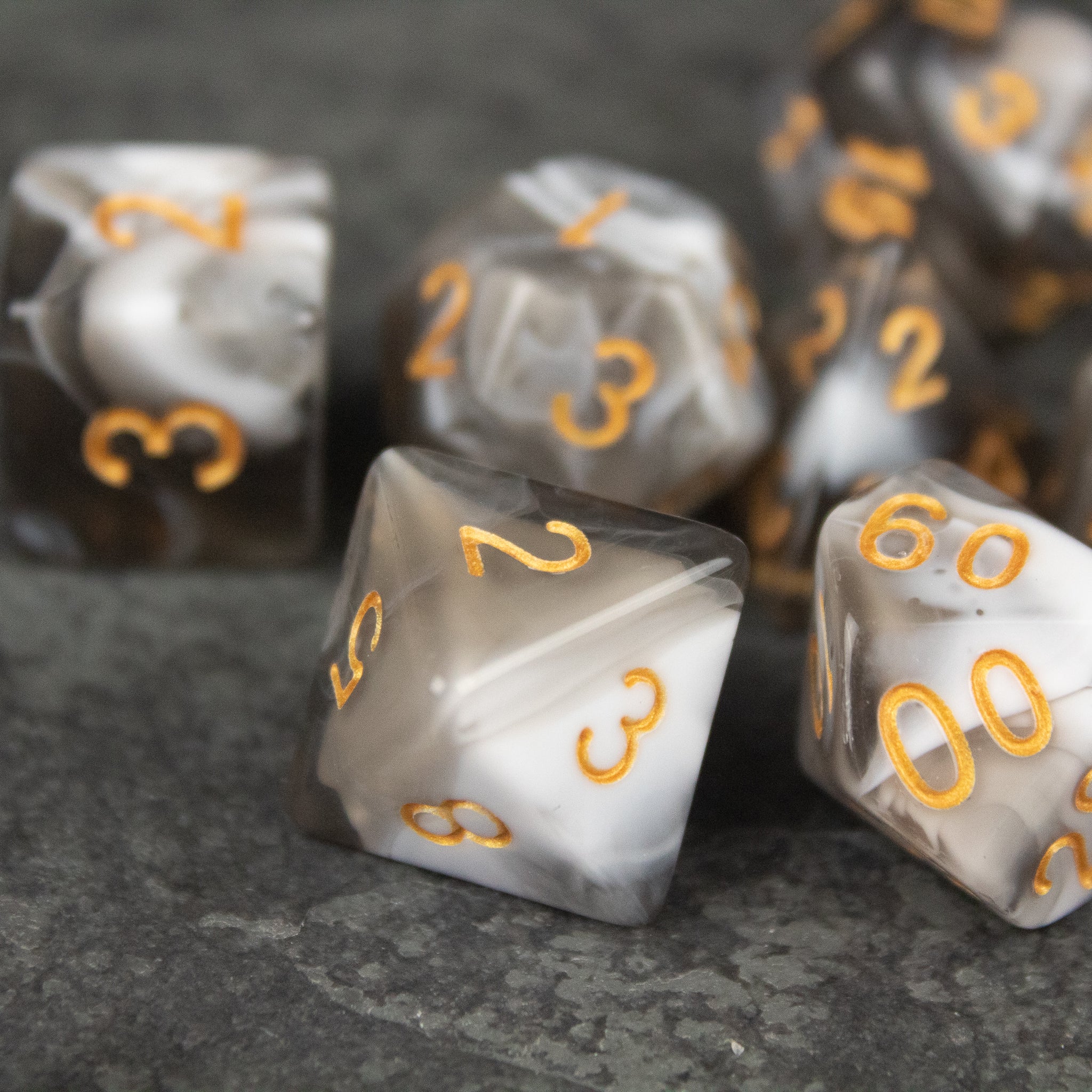 White and Gray Marbled Dice Set - White and gray marbled acrylic dice set with gold numbers, including various polyhedral shapes.