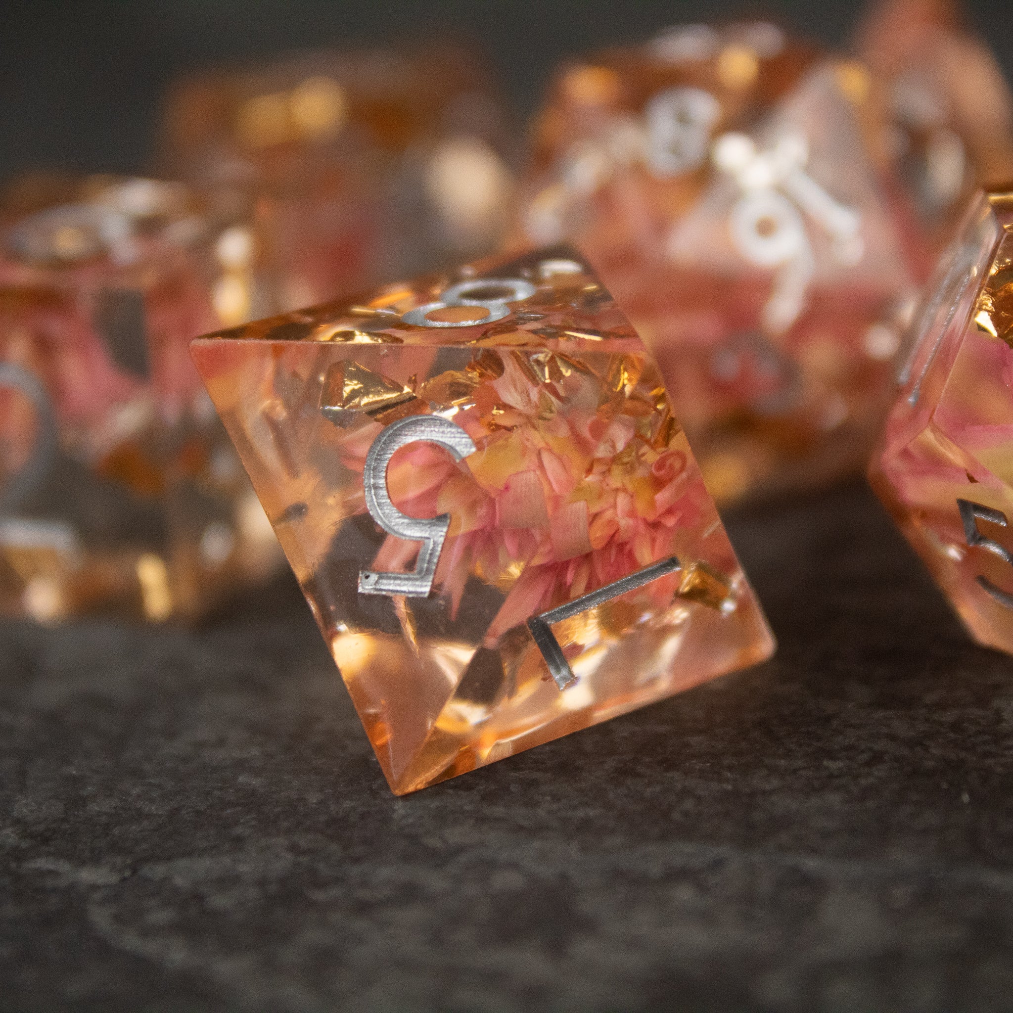Pink Flower Sharp Edge Dice Set - Transparent pink sharp edge die with embedded delicate pink flowers and white numbers.