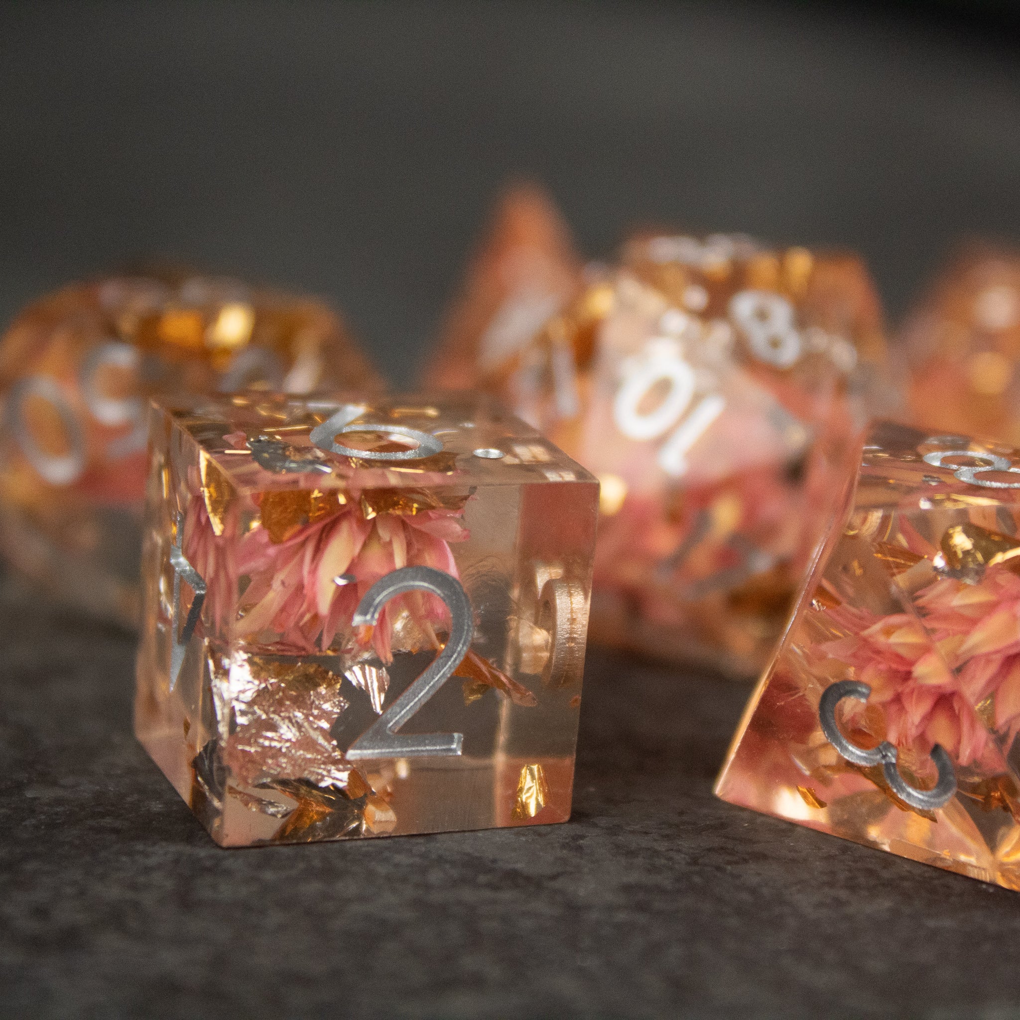 Pink Flower Sharp Edge Dice Set - Transparent sharp-edged dice with pink flowers and silver numbers inside.